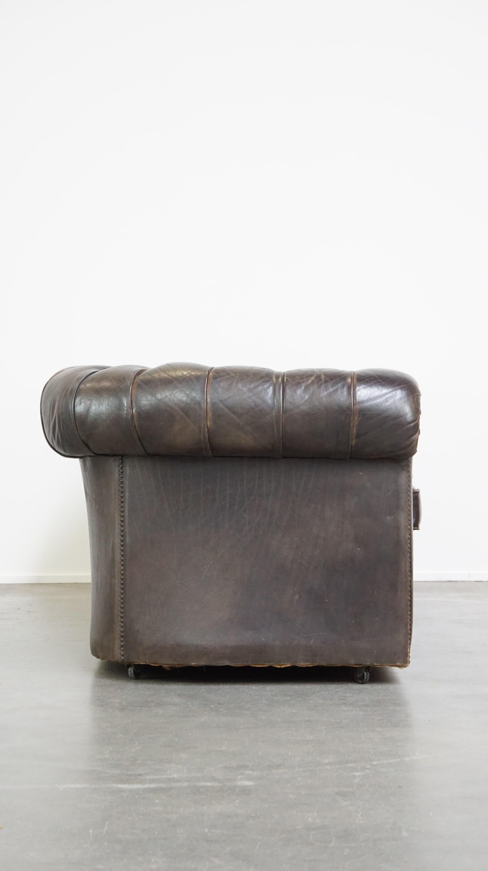 Offert ce vieux canapé Chesterfield 3 places en cuir de vachette marron foncé avec beaucoup de caractère.

Ce magnifique et ancien canapé Chesterfield 3 places marron foncé, en cuir de vachette, attire tous les regards ! Il est équipé de coussins