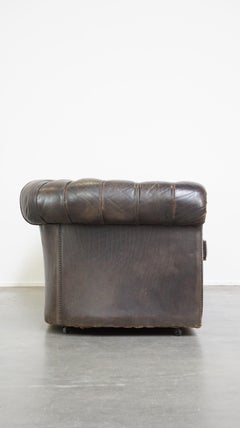 Old dark brown 3-seater cowhide chesterfield sofa with lots of character