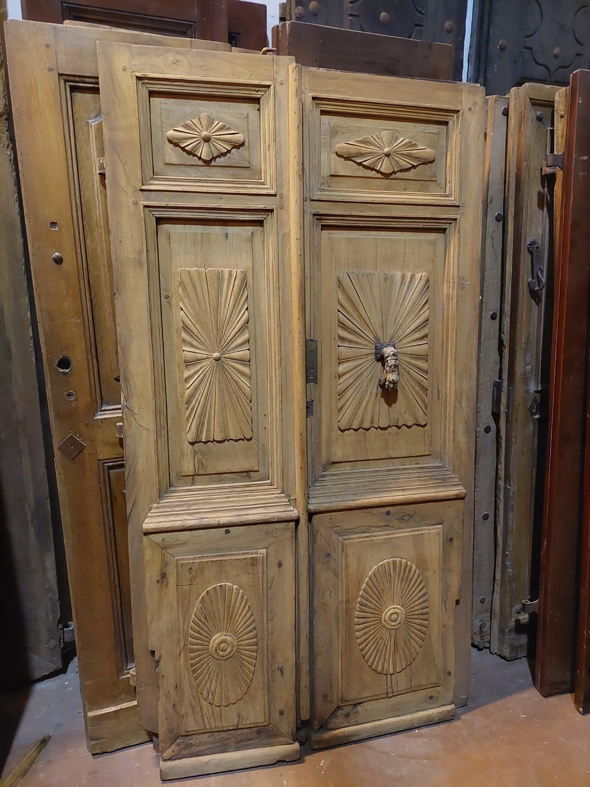 Antique entrance door, double wing, richly carved in solid poplar wood, smooth back and complete front with knocker and irons for wall mounting, hand-built by a craftsman in the 19th century in Italy.
Push opening, double non-symmetrical door,