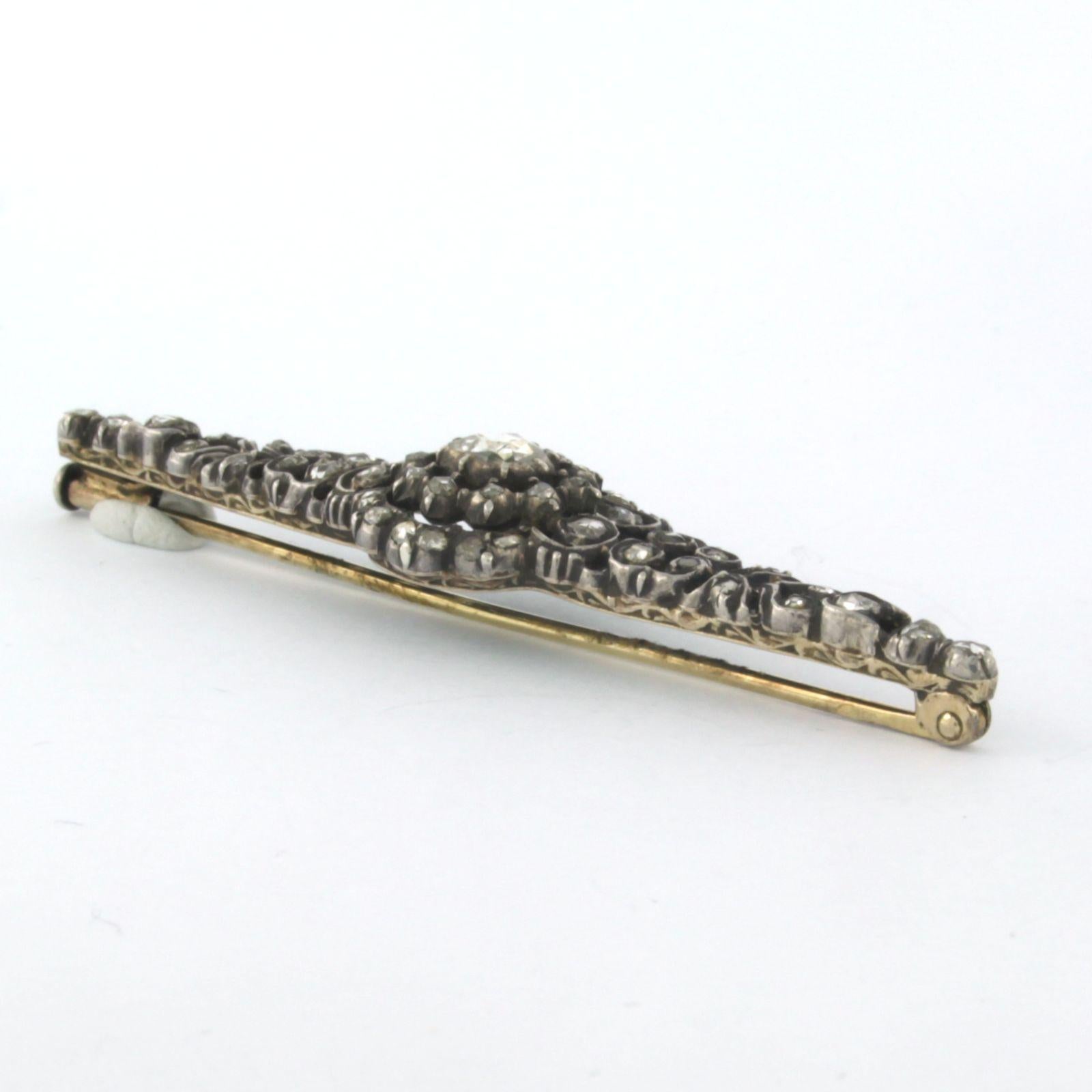 14k gold with 925 silver brooch set with rose cut diamond to. 0.50ct G/HSI

Detailed description

the brooch is 1.5 cm high and 6.3 cm wide

total weight: 7.1 grams

occupied with:

- 1 x (4.4 mm - 5.4 mm) rose cut diamond, approx. 0.30 carat

color
