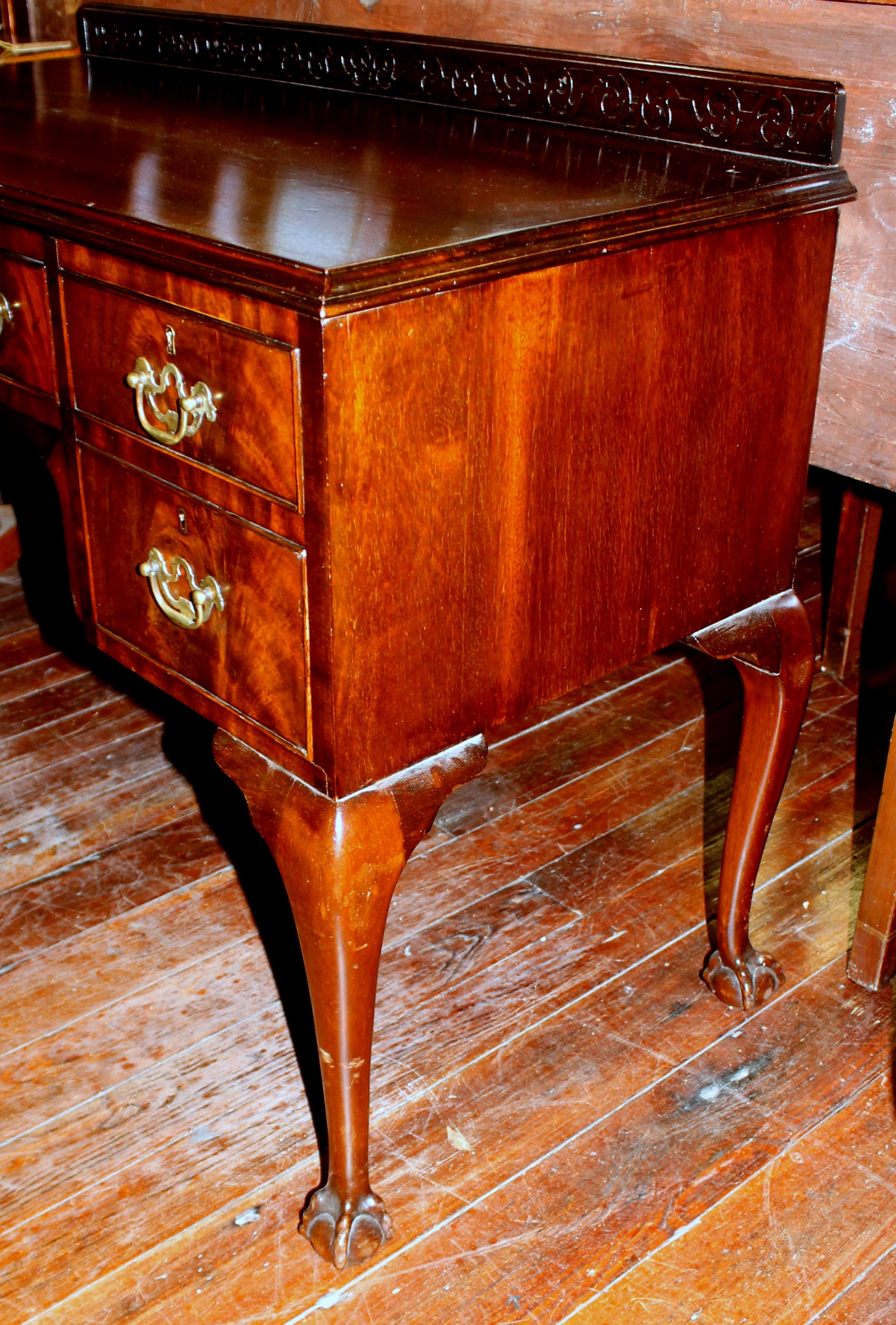 Fabulous Old English figured mahogany Chippendale style desk, Chippendale Revival made during the Edwardian period; with handsome flame or crotch mahogany veneered fronts; handsome hand carved and fretted gallery back (which is removable); lovely