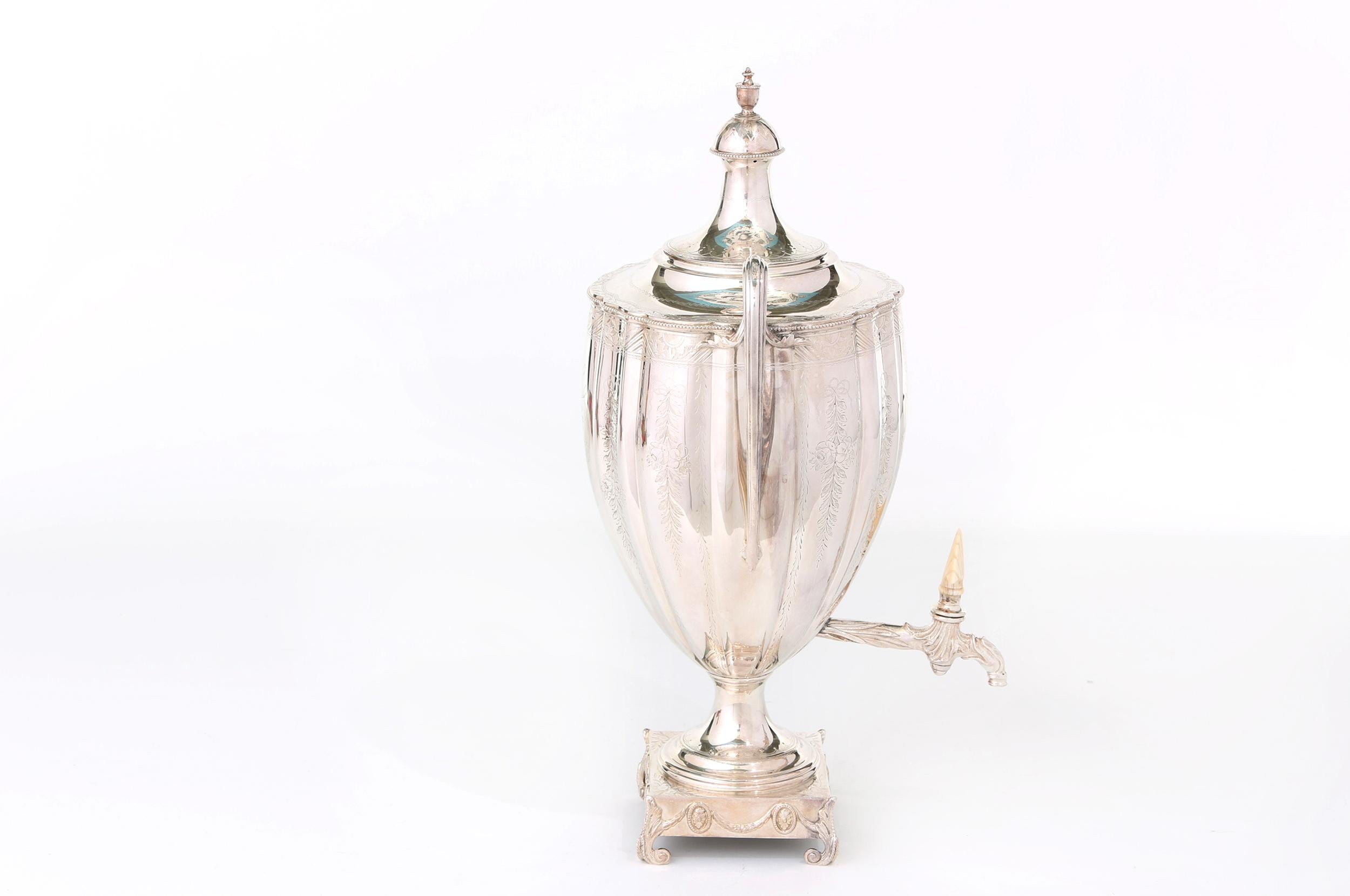 Vase shaped antique English silver plated tea urn / samovar with bright cut hand engraved with typical neo-classical leaf, flower and garland engraving.  The large loop handles have large acanthus leaf termini.  The engraved spout has a hand carved