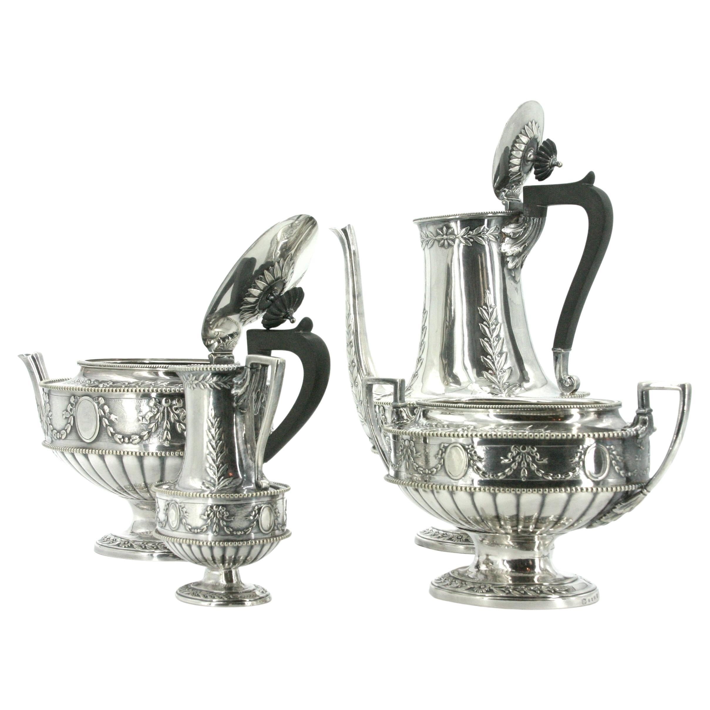 Beautifully crafted 19th century English silver plate tableware four pieces tea/coffee service. The coffee/tea features intricate exterior garland floral details and black wood handle. The set include Coffee pot 10