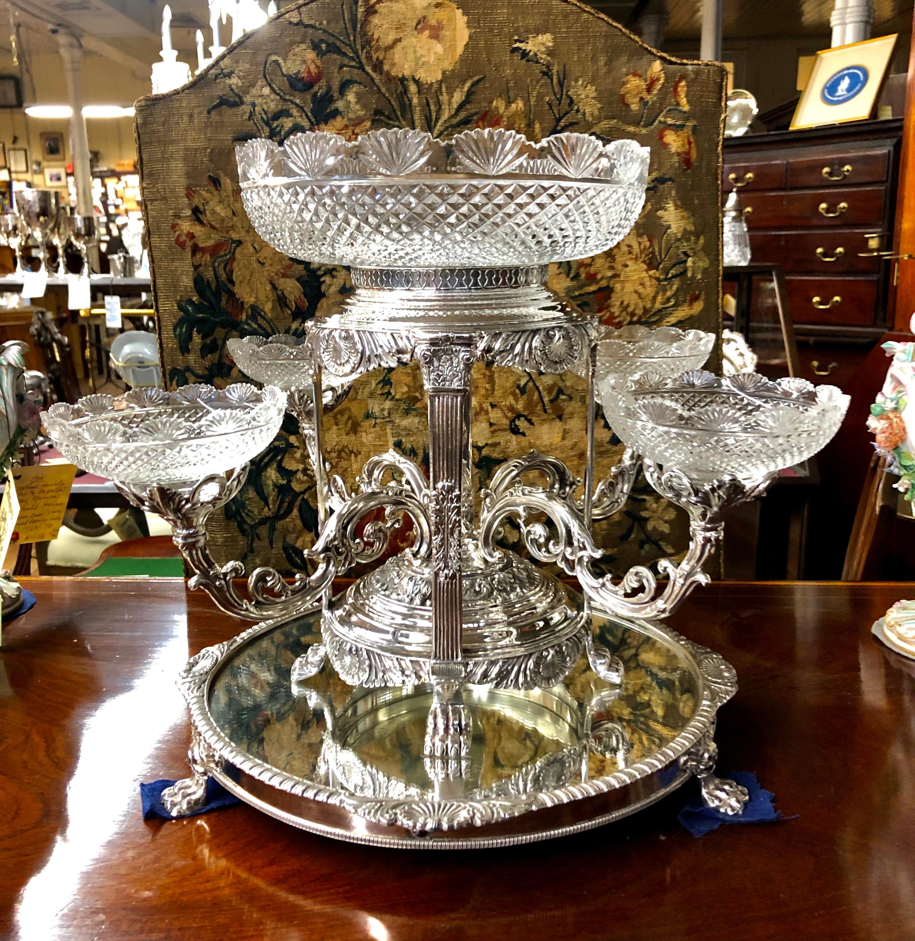 Extraordinary Old English silver plate and hand cut crystal four-branch Epergne Centerpiece with removable arms (numbered for precise placement) and magnificent cut crystal dishes standing upon a matching round mirror plateau with shell and gadroon