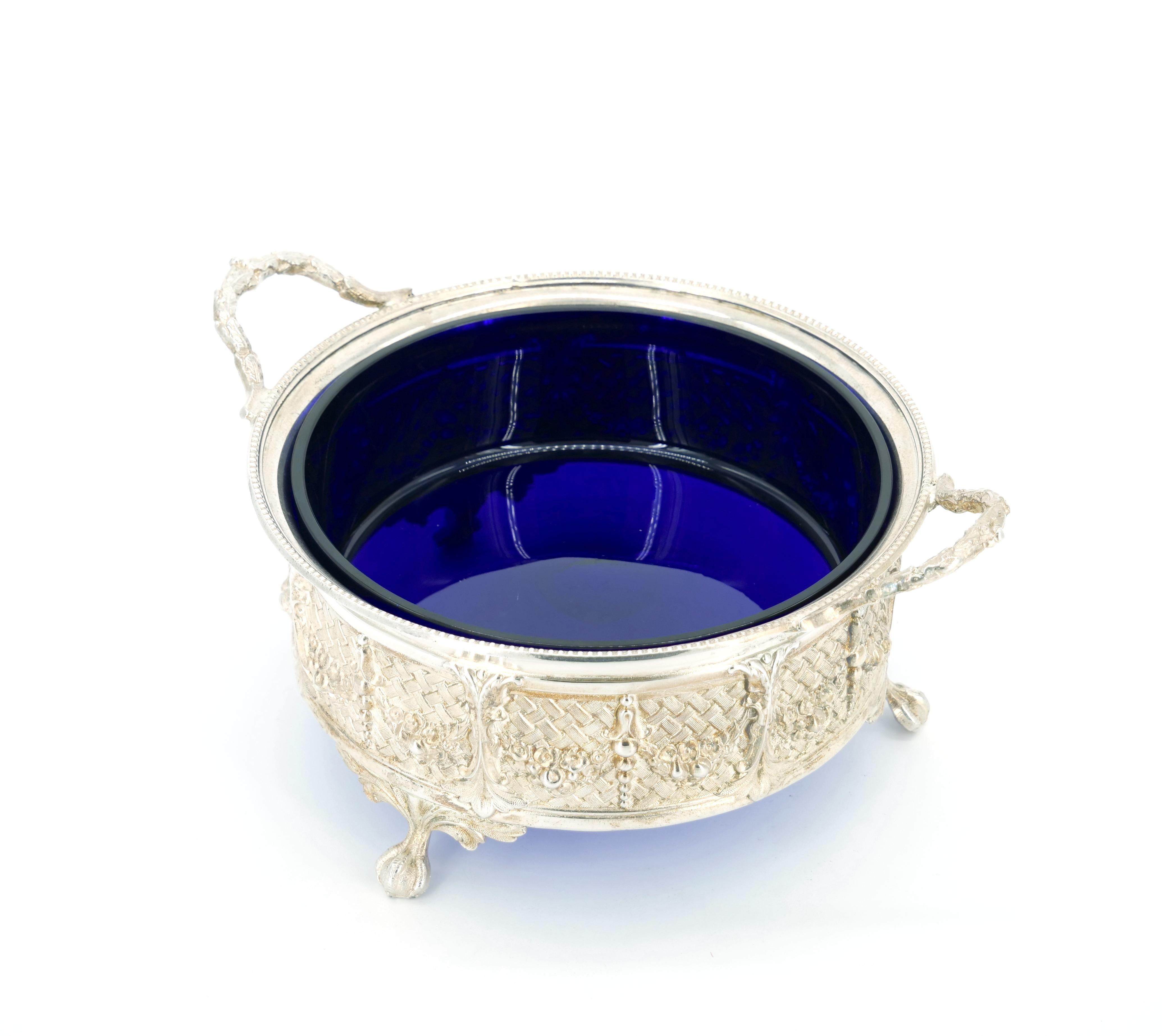 Transform your dining experience with this exquisite Old English Silver Plate serving comport disk, featuring a captivating round cobalt blue glass insert. The silver holding frame is a testament to craftsmanship, adorned with an intricate all-over