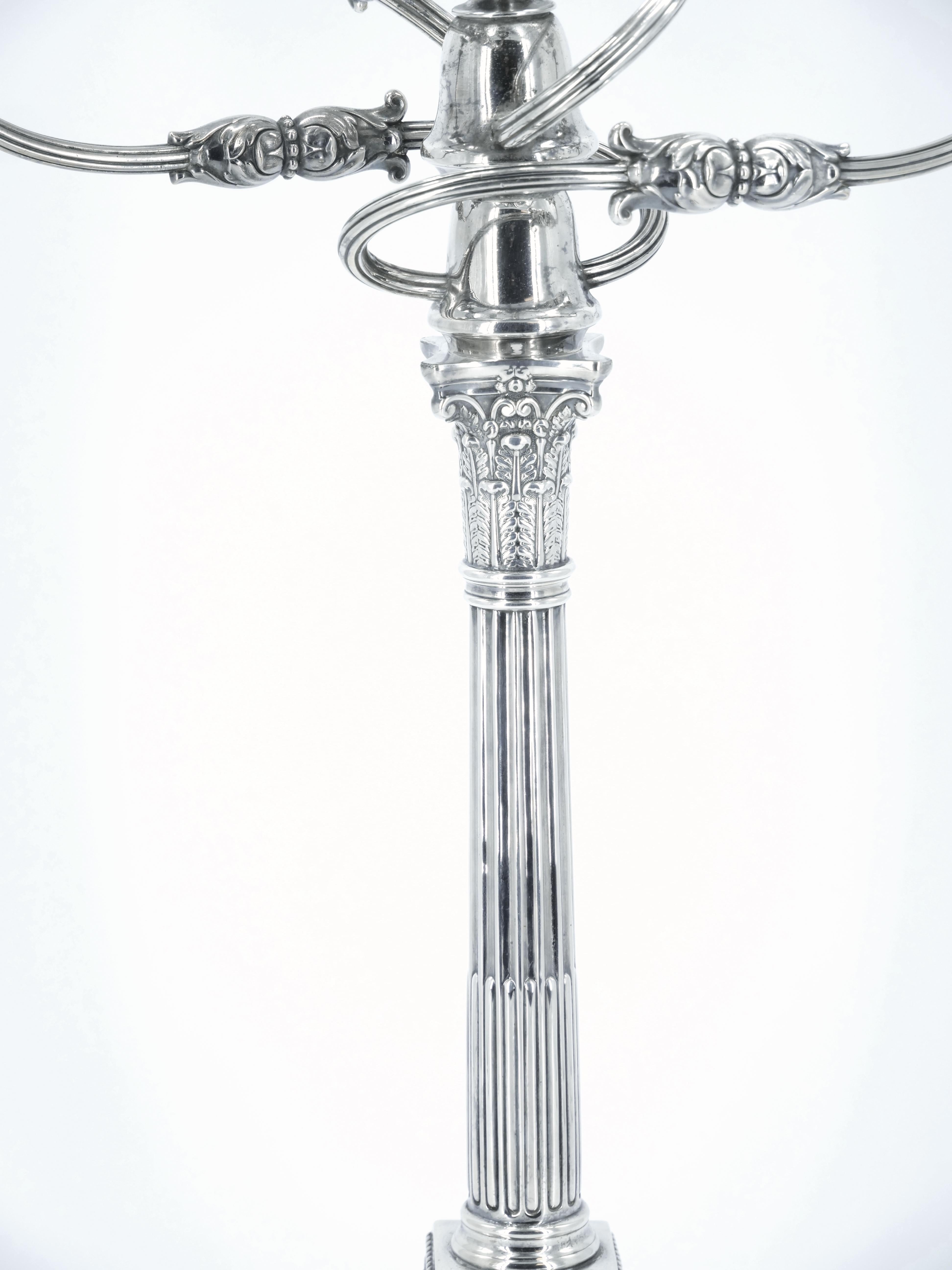 Exceptionnel candélabre à cinq lumières en métal argenté anglais du XIXe siècle, réalisé par James Dixon, avec des motifs finement repoussés et ciselés, une colonne cannelée et des chandeliers soutenus par des chapiteaux de style corinthien.  Se