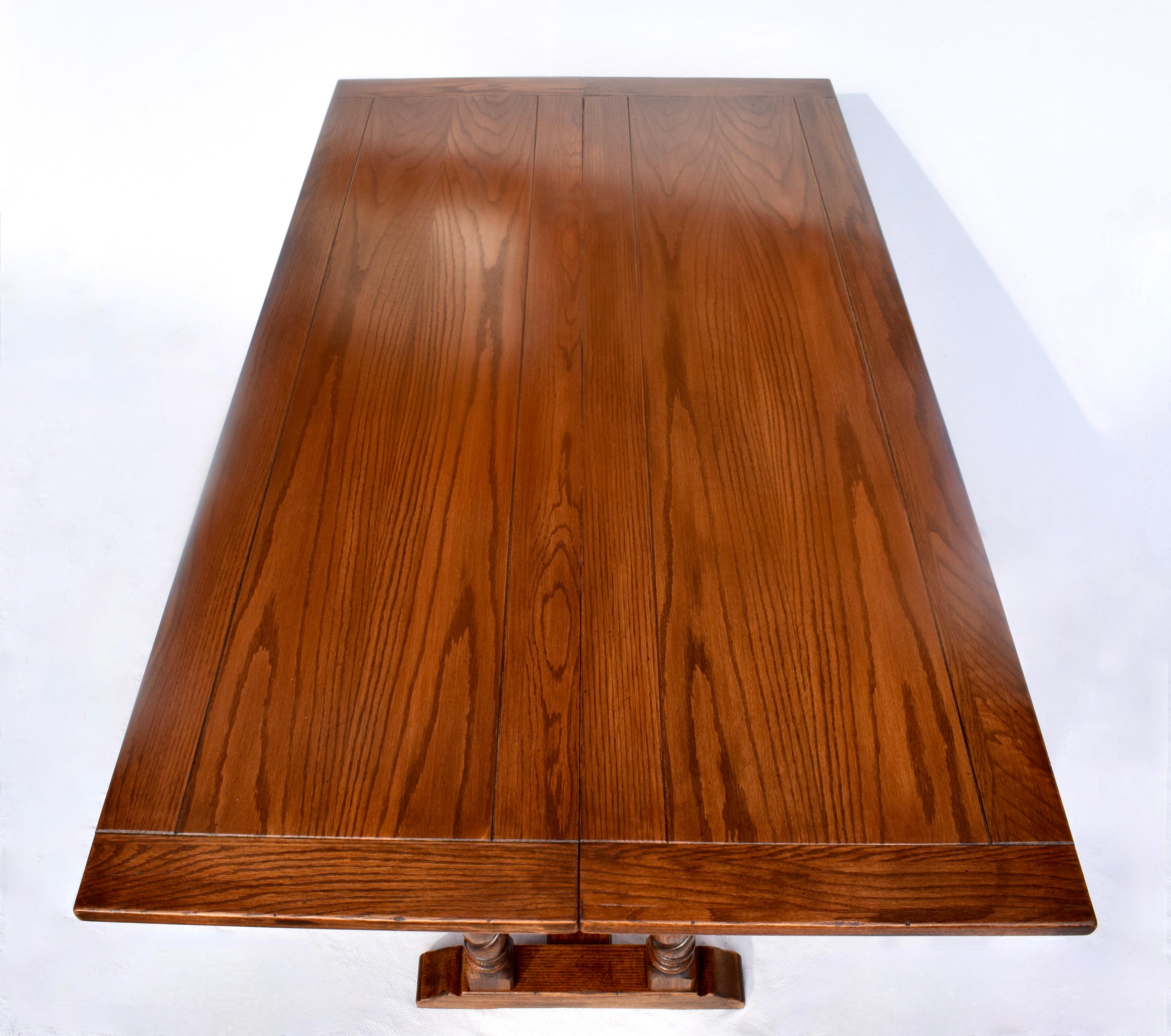 A substantial barley twist solid Oak table with single folding leaf option for versatile use as dining, console or buffet table. The lower hinged leaf is attached to metal tracks sliding mechanisms allowing for the open leaves to solidly center on