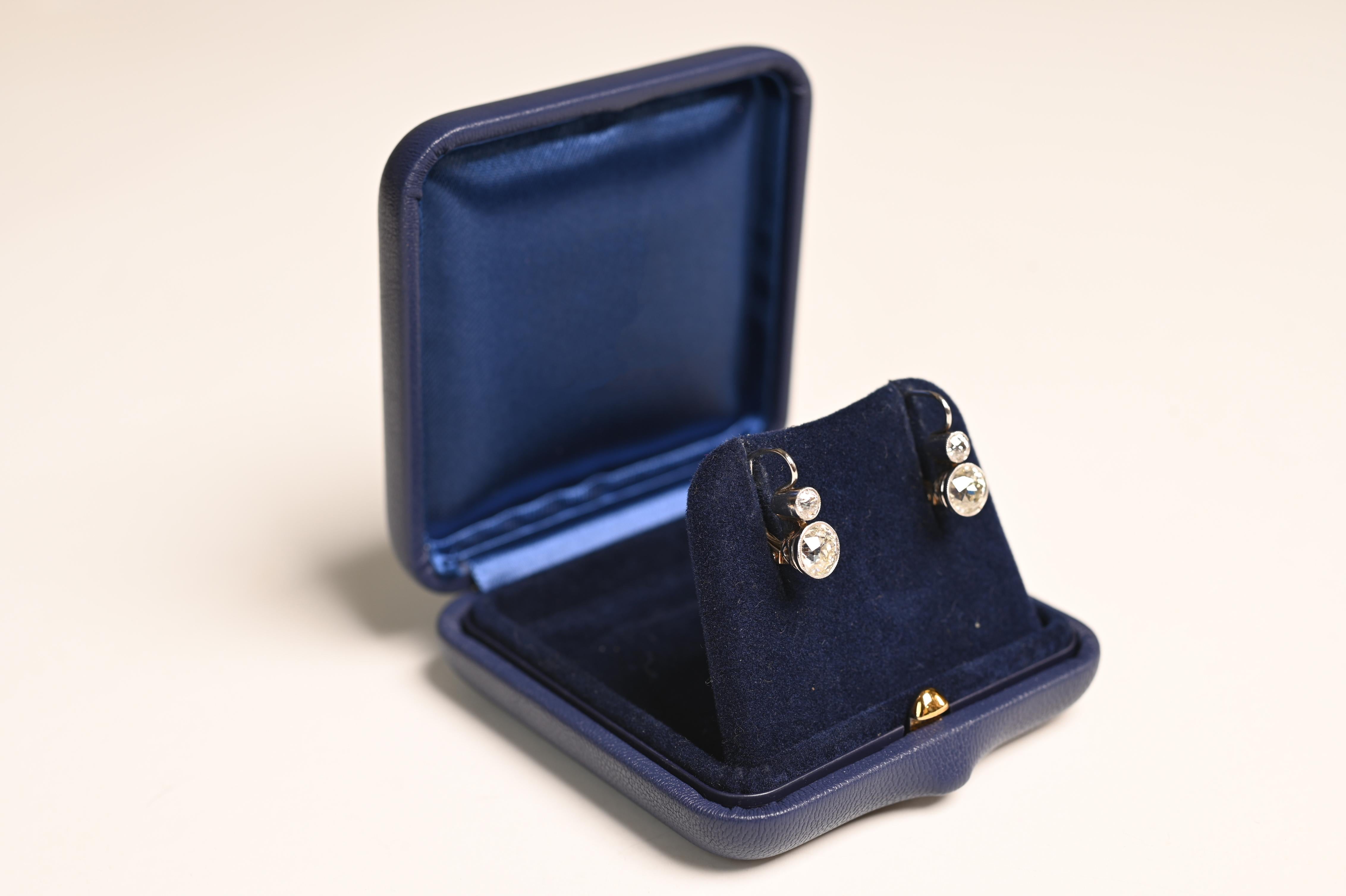 Cette exquise paire de boucles d'oreilles présente une étonnante combinaison de diamants de taille européenne ancienne, magistralement sertis dans du platine et de l'or jaune 18 carats. Les deux diamants du bas, d'un poids combiné d'environ 2,30