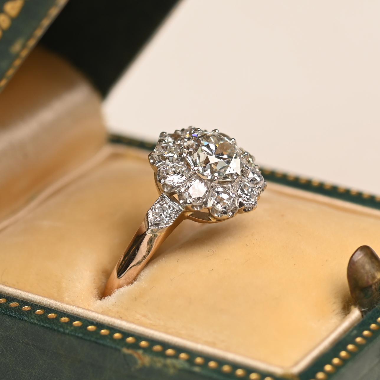 Questo elegante anello ha al centro un diamante vecchio taglio europeo del peso di circa 0,90 carati, di colore I e purezza VS1. Il diamante è saldamente incastonato all'interno di un grappolo di altri diamanti taglio vecchio europeo, ognuno dei