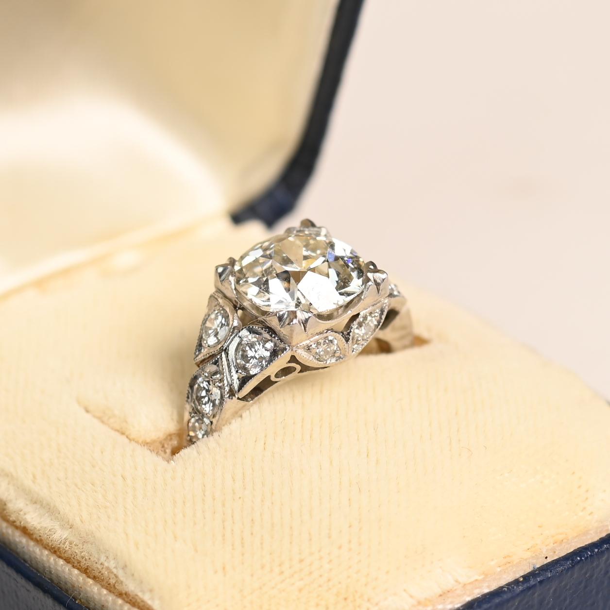 Exuding timeless elegance and vintage charm, this exquisite engagement ring showcases a stunning Approx. 2.60-Carats old European cut diamond as its centerpiece. Graded J color and VS2 clarity, the diamond radiates a soft, romantic brilliance,
