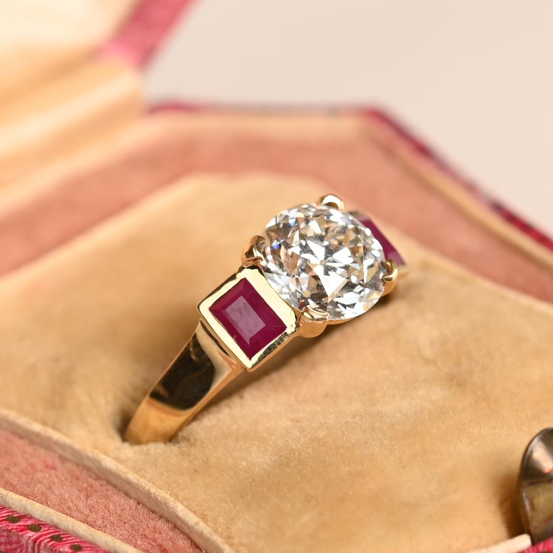 Cette extraordinaire bague de fiançailles est un mélange saisissant d'élégance vintage et de savoir-faire artisanal. En son cœur se trouve un captivant diamant de taille européenne ancienne d'environ 1,60 carat, certifié par la GIA, d'une couleur K