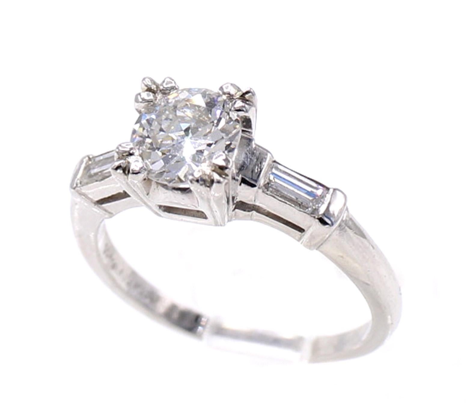 Gorgeous 0.91 carat Old European cut diamond set in a handmade fishtail prong polished platinum mounting with bright white baguette diamonds on each side. The beautiful cut, wider facets, and higher crown of this old cut stone bring an amazing fire,