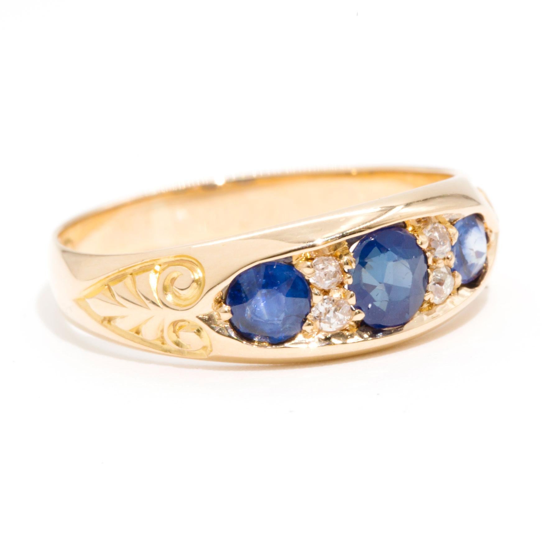Forged in 18 carat yellow gold is this lovely vintage ring featuring three charming blue natural sapphires and four delightful old European cut diamonds set in a intricate patterned band. We have named this charming vintage ring The Venus Ring. The
