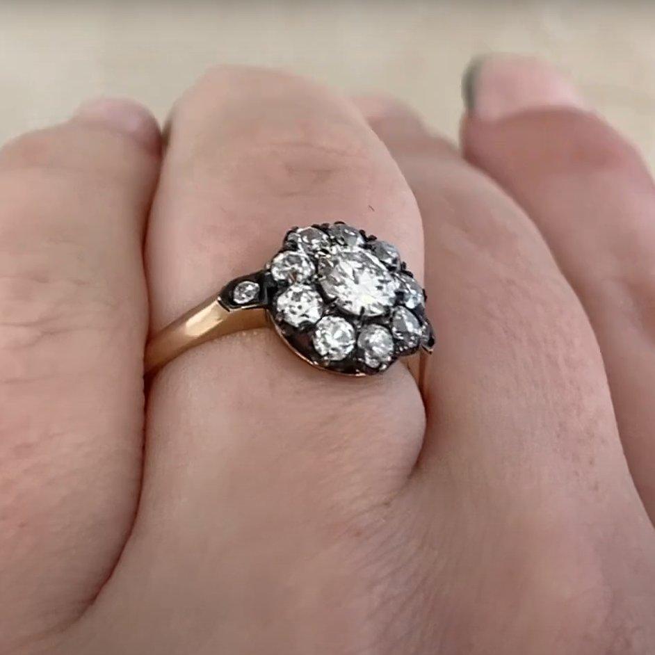Este exquisito anillo en racimo de diamantes exhibe un diamante de talla europea antigua de 0,50 quilates en su centro, engastado con garras para resaltar su brillo atemporal. De color J y claridad VS1, la piedra central irradia encanto y carácter