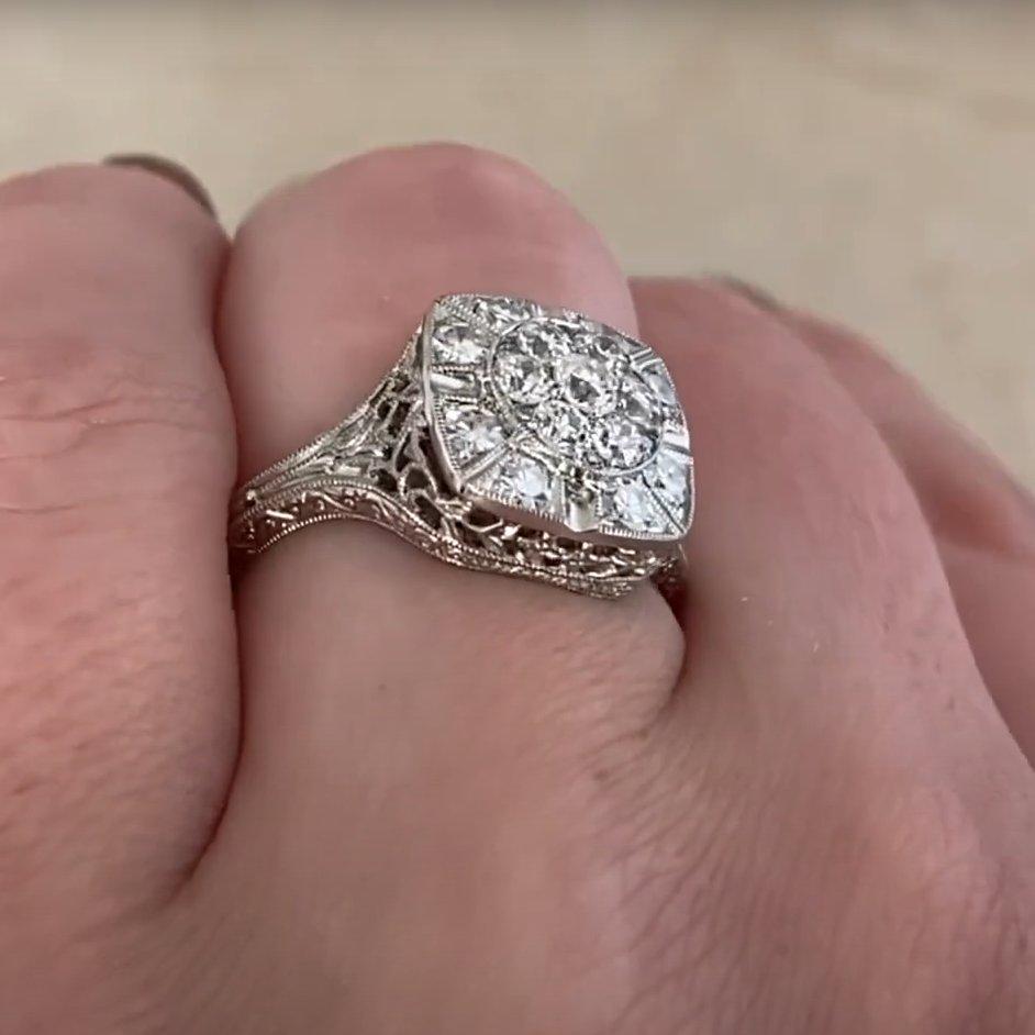 This exquisite ring features a sparkling center cluster of diamonds with a total approximate weight of 0.50 carats. The diamonds are graded J color with VS2 to SI1 clarity, offering a beautiful balance of brilliance and warmth. Framing the central
