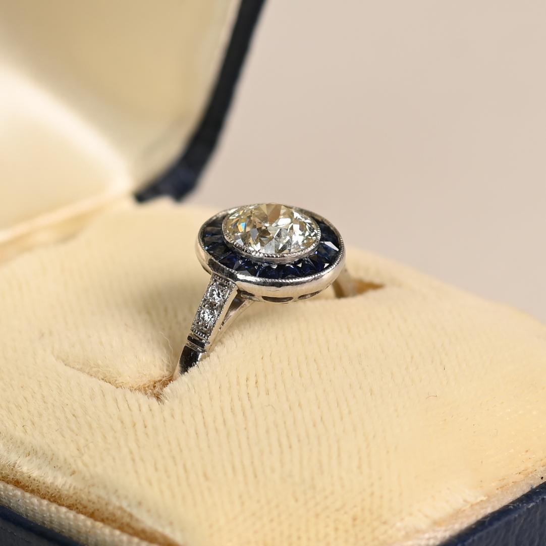 Cette exquise bague de fiançailles de type halo met en valeur un captivant diamant de taille européenne ancienne d'environ 1,00 carat, serti en chaton pour mettre en valeur sa brillance intemporelle. Classé K en couleur et VS1 en clarté, le diamant