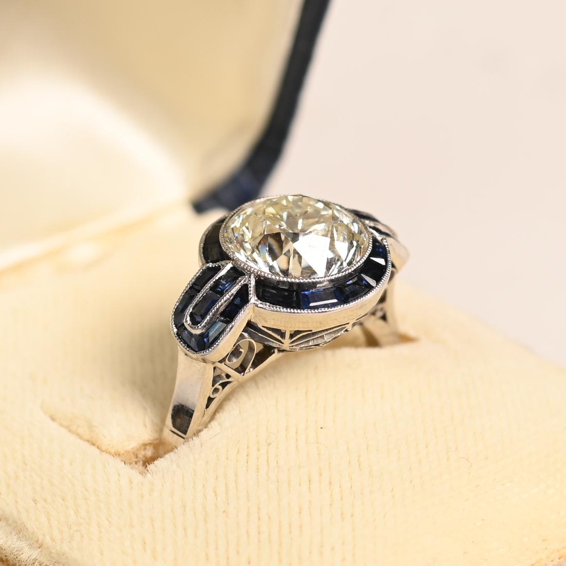Este exquisito anillo presenta un deslumbrante diamante de talla europea antigua de aprox. 3,00 quilates, clasificado K en color y VS2 en claridad. La piedra central está engastada con seguridad en un bisel, lo que realza su brillo al tiempo que