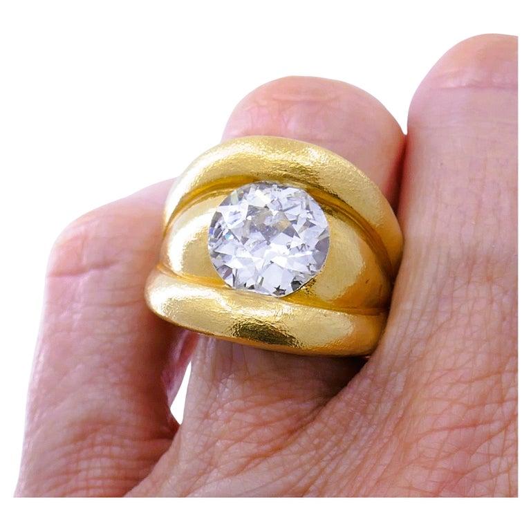 Une impressionnante bague en or 18 carats avec un diamant de taille européenne.
La combinaison frappante du gros diamant (4,86 carats) monté au ras de l'or crée un superbe effet. L'or est légèrement texturé, ce qui ajoute à la massivité de la bague.