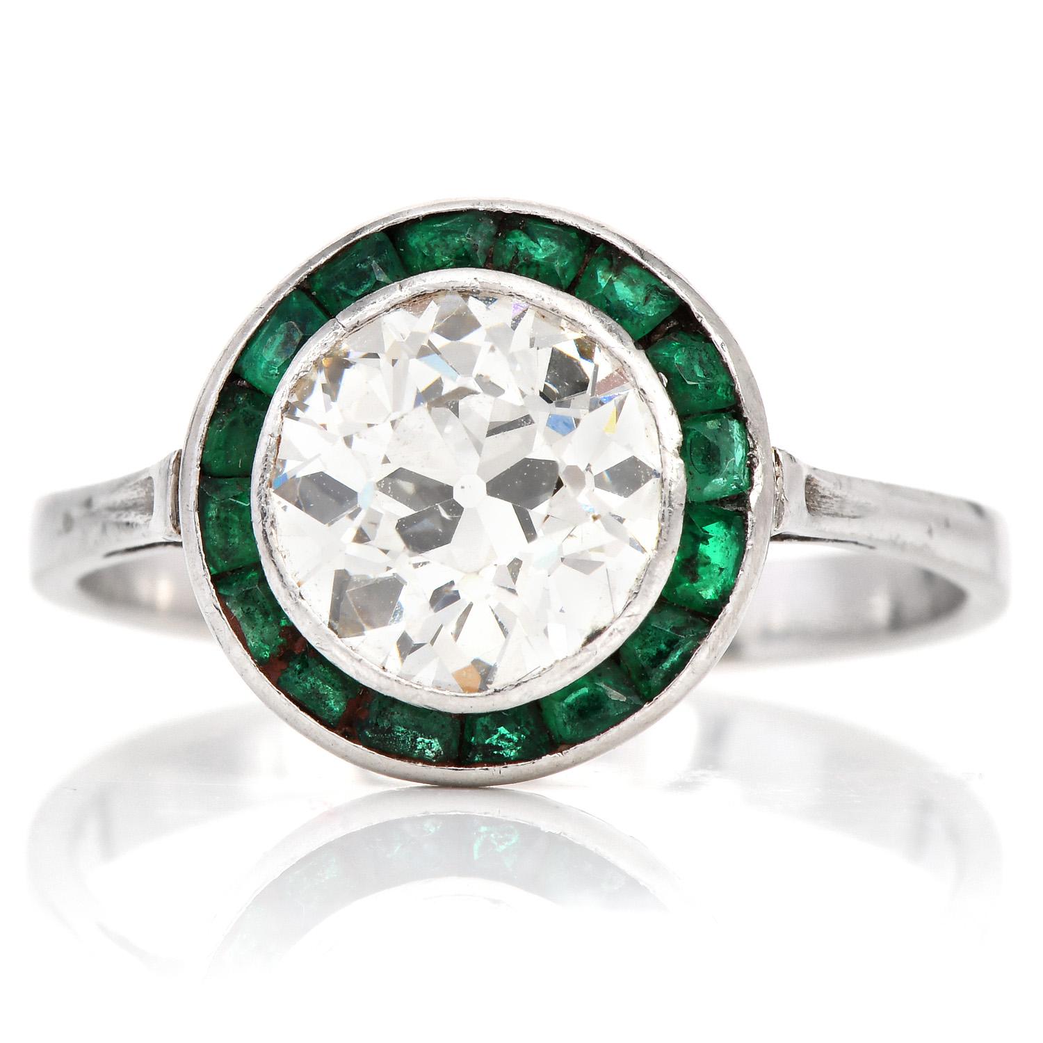 An exquisite Old European cut center diamond enhanced by a halo of Emerald gemstones.

This exquisite ring is crafted in solid Platinum. Centered with an Old European cut Genuine Diamond, Bezel set, weighing 2.00 carat, H-I  color &