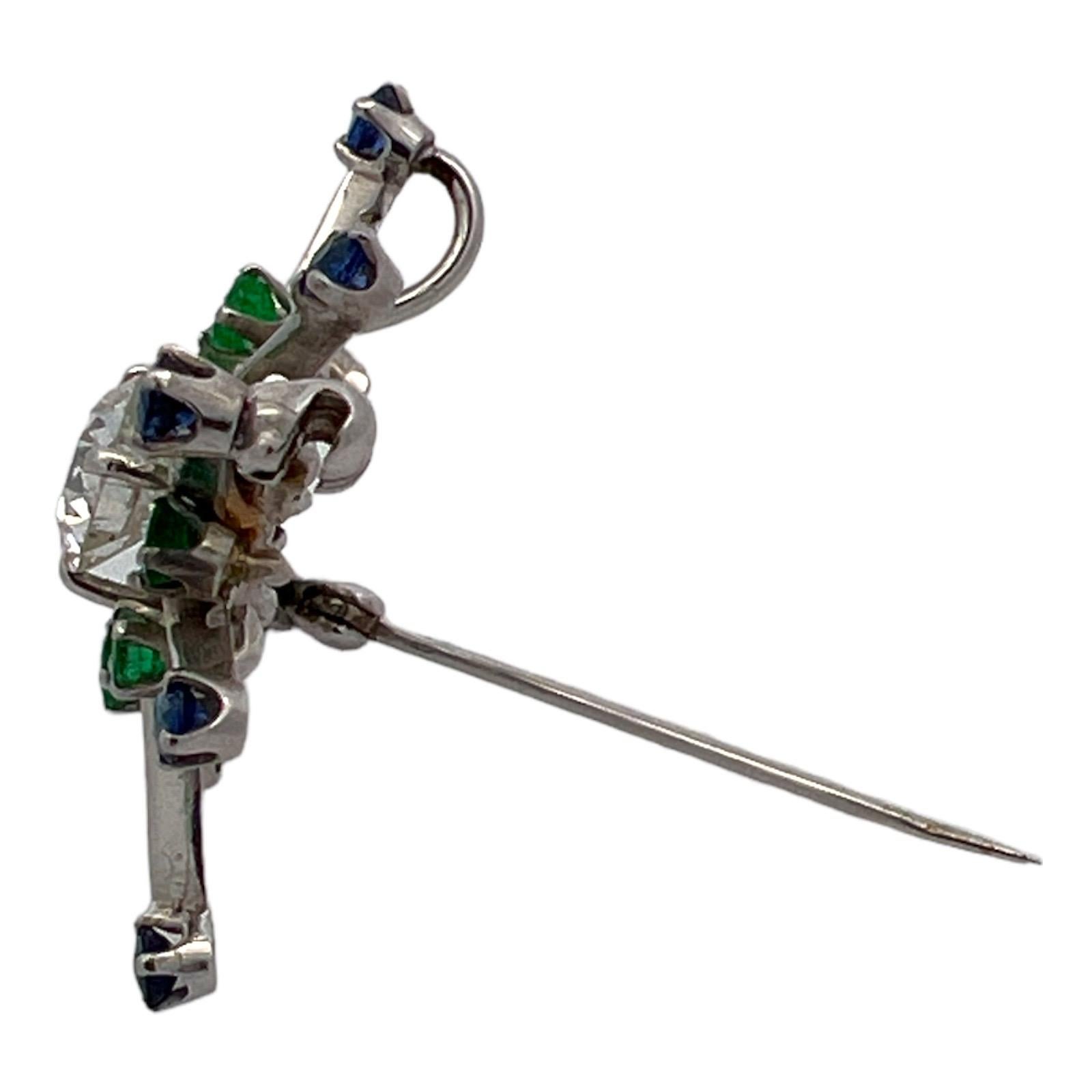 Gorgeous diamond, sapphire, and emerald pendant and pin handcrafted in 14 karat white gold. The vintage pendant features a center Old European cut diiamond weighing approximately 1.05 carats and graded H color and SI1 clarity. Another 8 natural