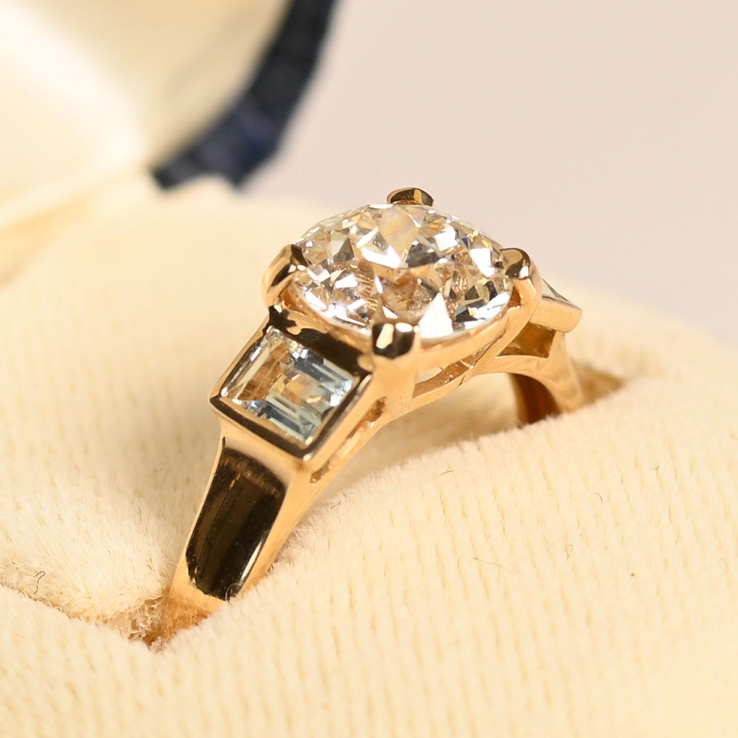 Cette magnifique bague présente en son centre un diamant de taille européenne ancienne de 1,50 carat certifié par le GIA, de couleur J et de pureté VVS2. Son facettage distinctif apporte une brillance intemporelle, donnant à la pierre un éclat doux