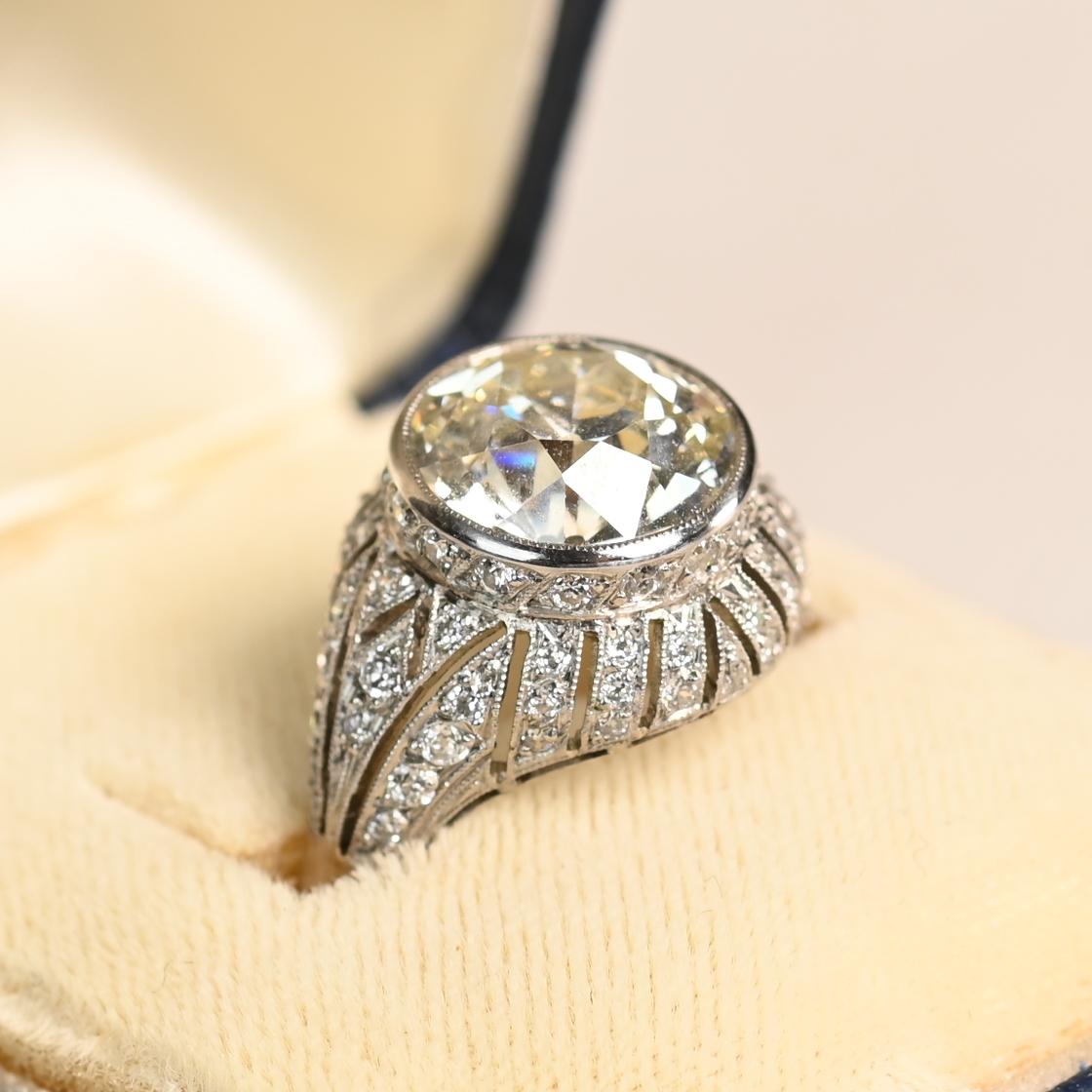 Este exquisito anillo de compromiso engastado en bisel exhibe un impresionante diamante de talla europea antigua de aprox. 4,50 quilates, de color L y claridad VS1. El facetado vintage del diamante irradia calidez y carácter, capturando la luz