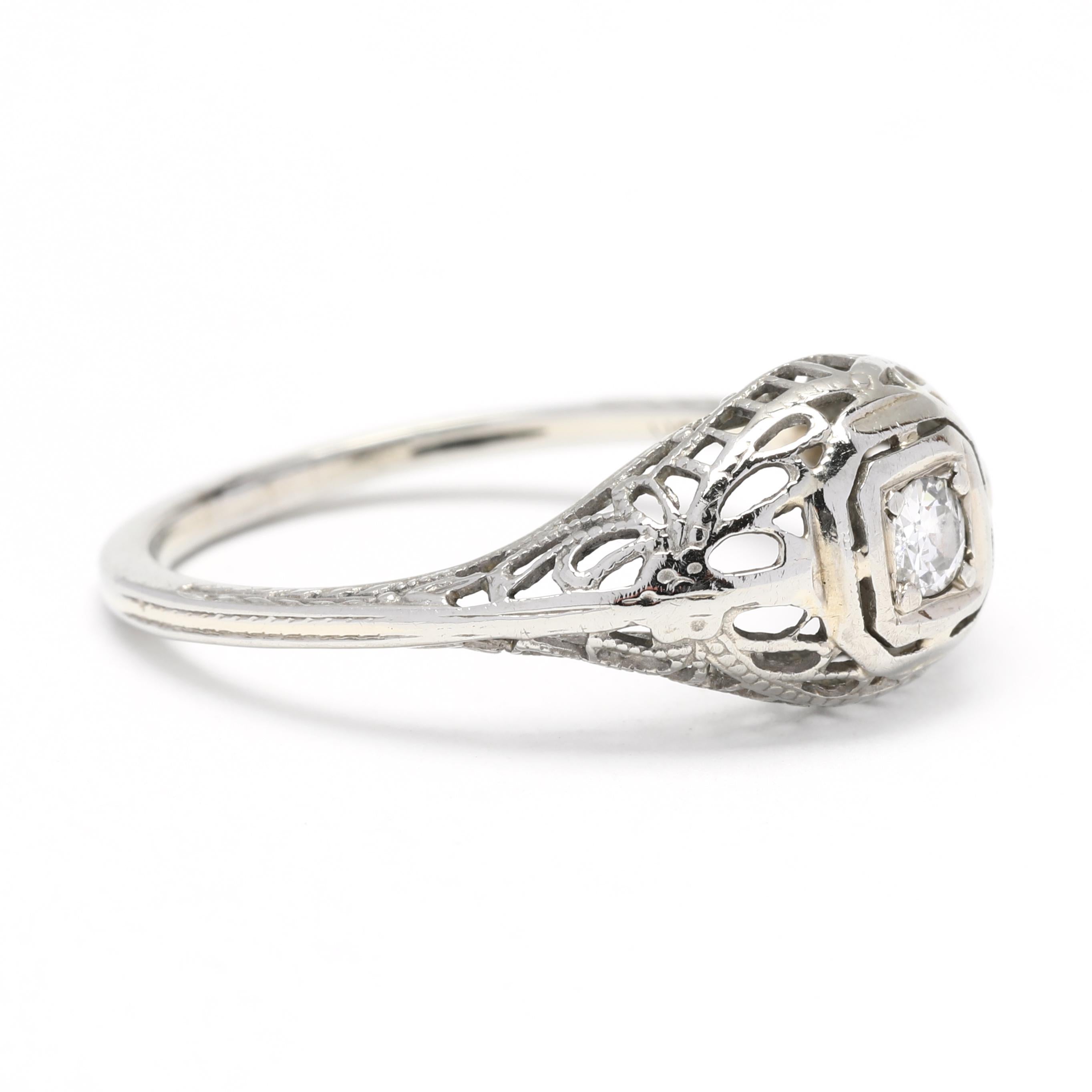 This stunning engagement ring is the perfect way to show your love and commitment. Featuring an enchanting Art Deco style, it is crafted in 18K white gold and set with a .07ct old European cut diamond. Delicate filigree details add an enchanting