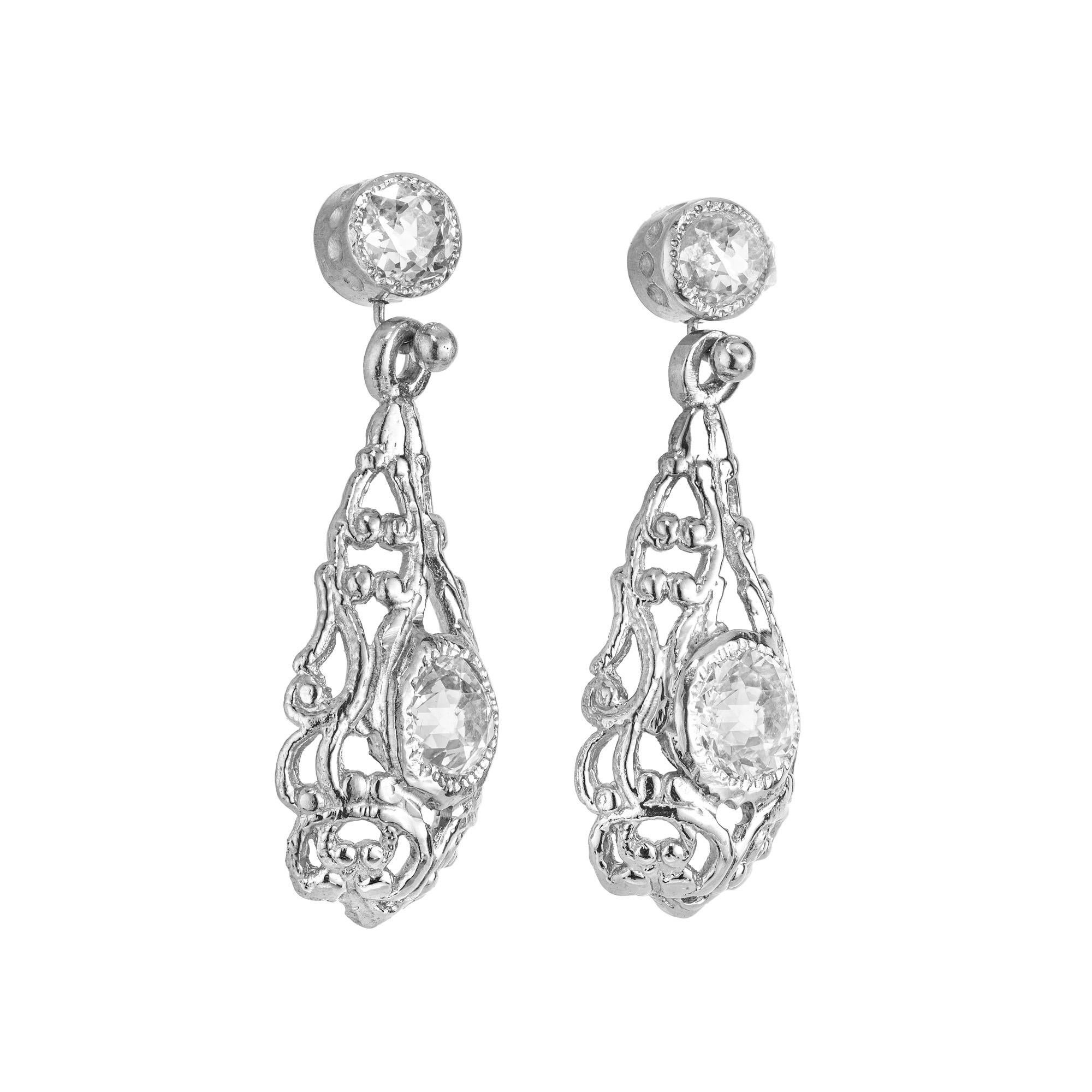1900’s handmade solid Platinum simple elegant dangle earrings.  All 4 diamonds are fine, bright, white, well cut and old European cut diamonds with raised crowns and small tables.  They have excellent sparkle and brilliance. The top is a simple hand