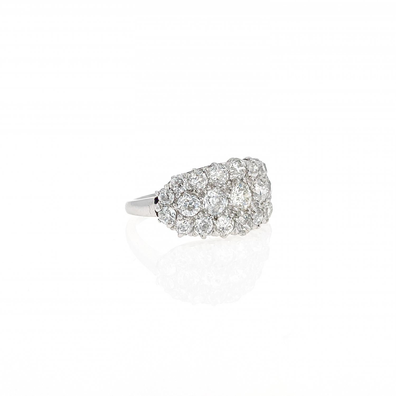 This ring is comprised of 23 old European cut diamonds weight approximately 3.25 carats total and is mounted in platinum. It  has a low-profile with wide band at the front and classic rounded shank to the back. This ring has a modern look yet the