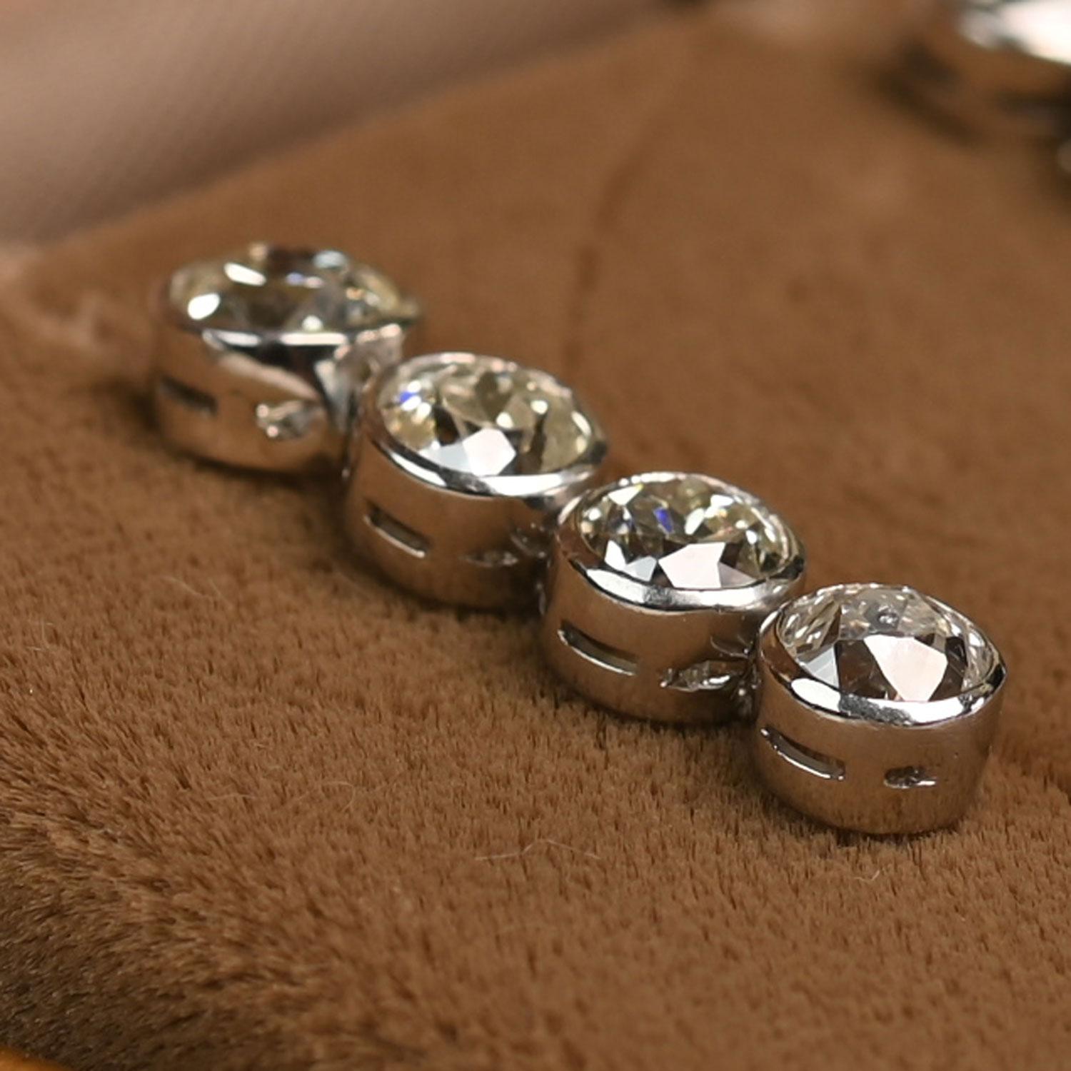 These elegant earrings feature a graceful hanging design, each showcasing four bezel-set diamonds that offer a clean, modern silhouette. The diamonds total approximately 2.40 carats and display K–L color with VS2–SI1 clarity, giving the pieces a