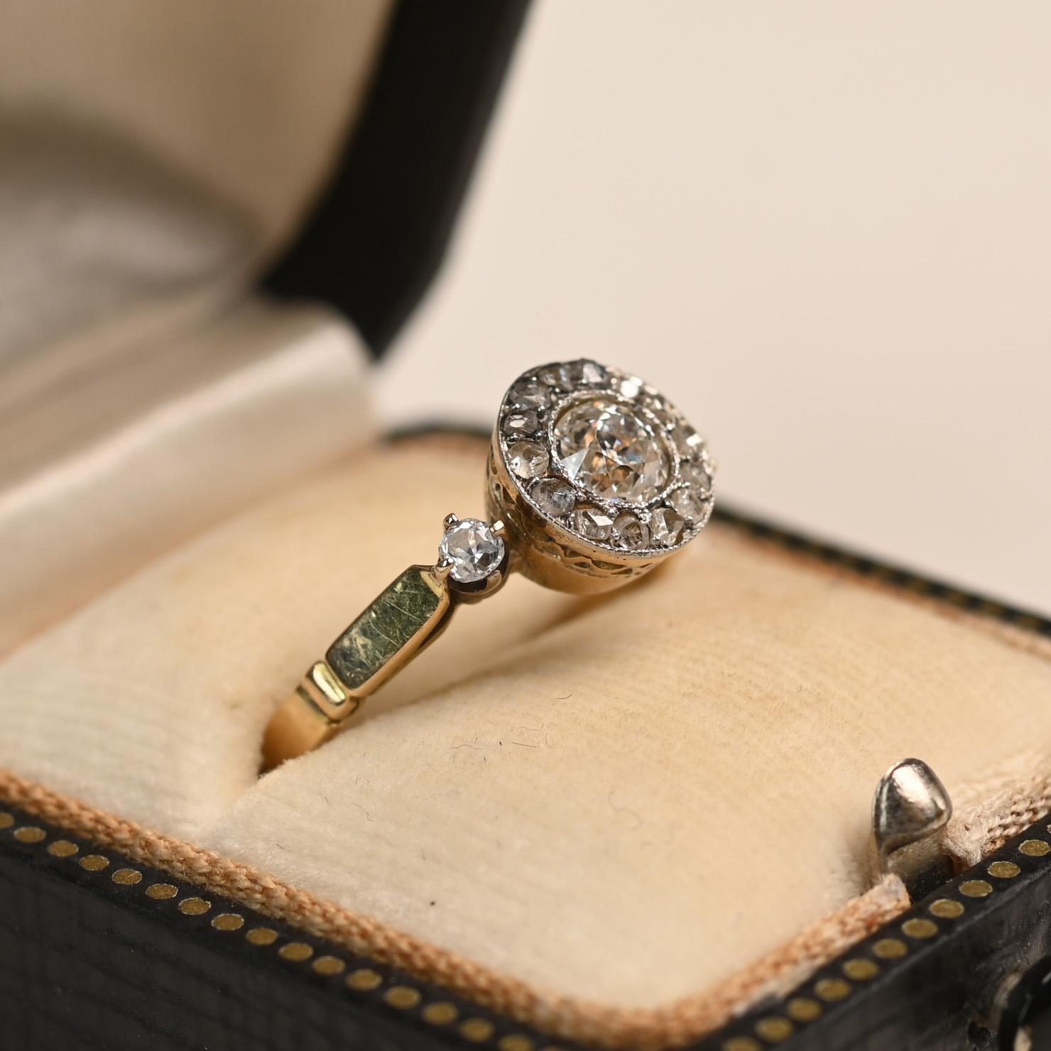 Un exquisito anillo de la época eduardiana que exhibe un diamante central de aproximadamente 0,40 quilates de talla europea antigua con un cálido color J y claridad VS2. Alrededor de la piedra central hay un delicado halo de diamantes talla rosa,