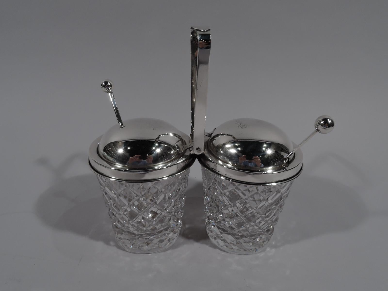 Old-fashioned sterling silver and glass double jam jar. Made by Hawkes in Corning, New York, circa 1950. Two jars each with straight and tapering sides and raised diaper pattern. Sterling silver collars joined by mount with open and tapering swing