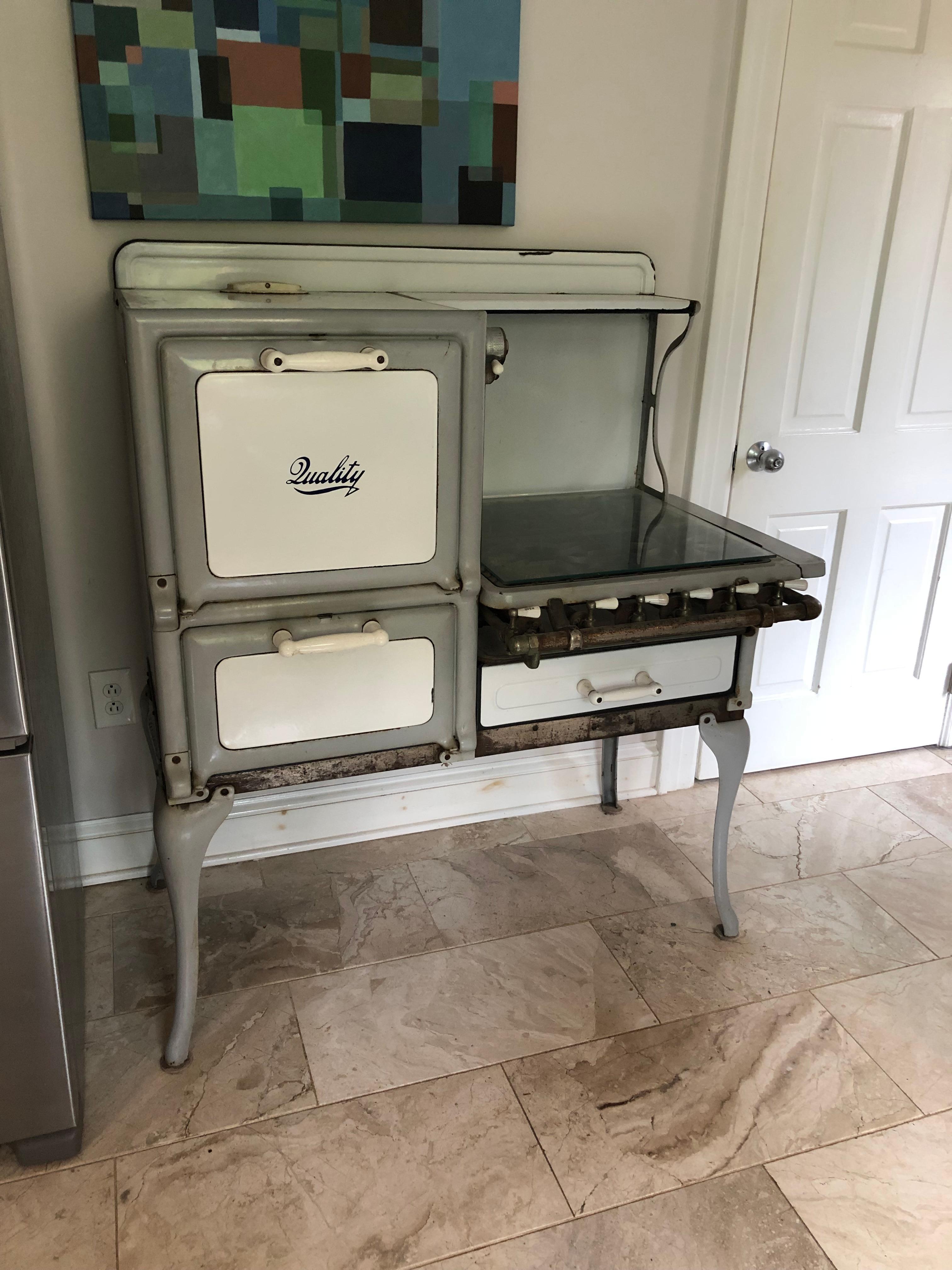 Charming old fashioned light grey, white, black and silver kitchen stove having the name 