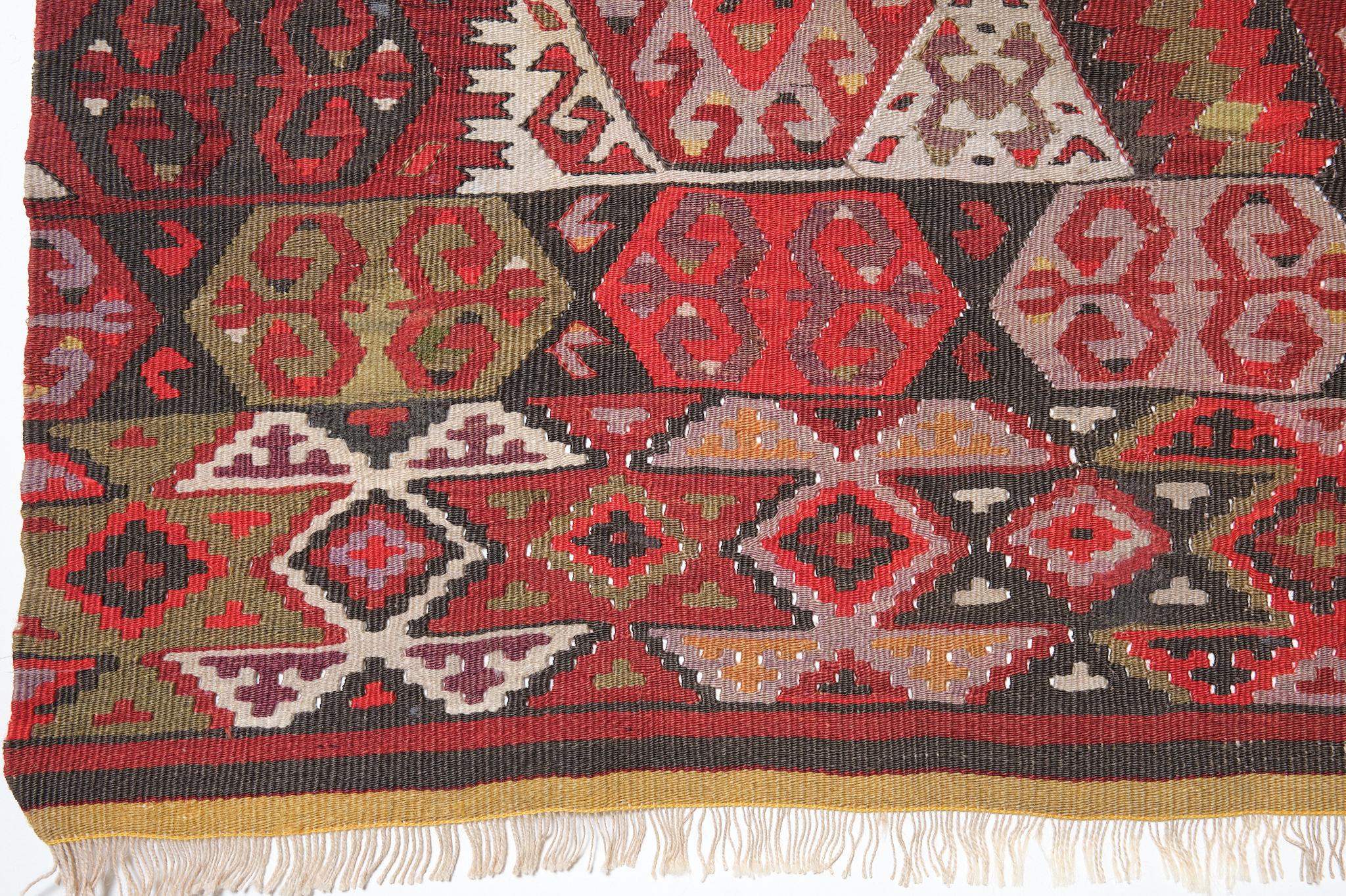 This is an old Western Anatolian Kilim from the Fethiye region with a red background and beautiful color composition.

The borders, medallions, and fields are densely woven with patterns. There are few rough edges, and it is a polite job. Red is