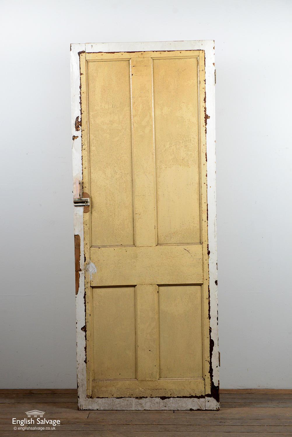 Reclaimed interior door with four panels which have been previously boarded over on both sides. Some damage to the door near the handle edge. Handle, lock and nail holes.