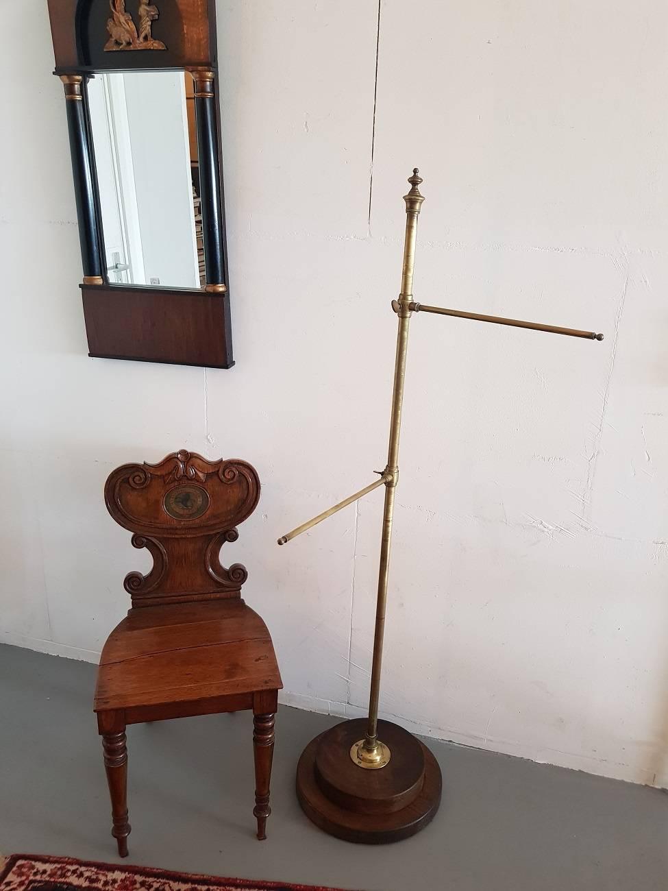 Old French brass towel stand with two adjustable arms and mounted on a heavy wooden base, circa 1900.

The measurements are,
Depth 38 cm/ 14.9 inch.
Width 35 cm/ 13.7 inch.
Height 150 cm/ 59 inch.
 