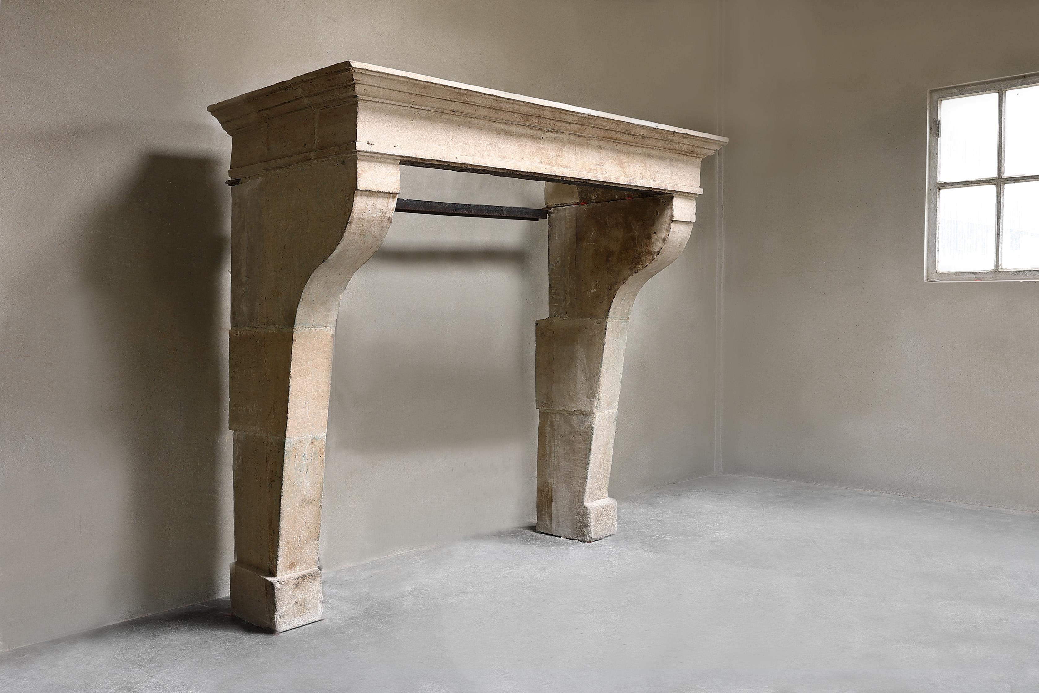 Compact antique of French limestone from the 19th century! A very nice rustic fireplace with warm colors, beautiful shapes and no ornaments. This fireplace comes from the area of Beaune, a city in France.