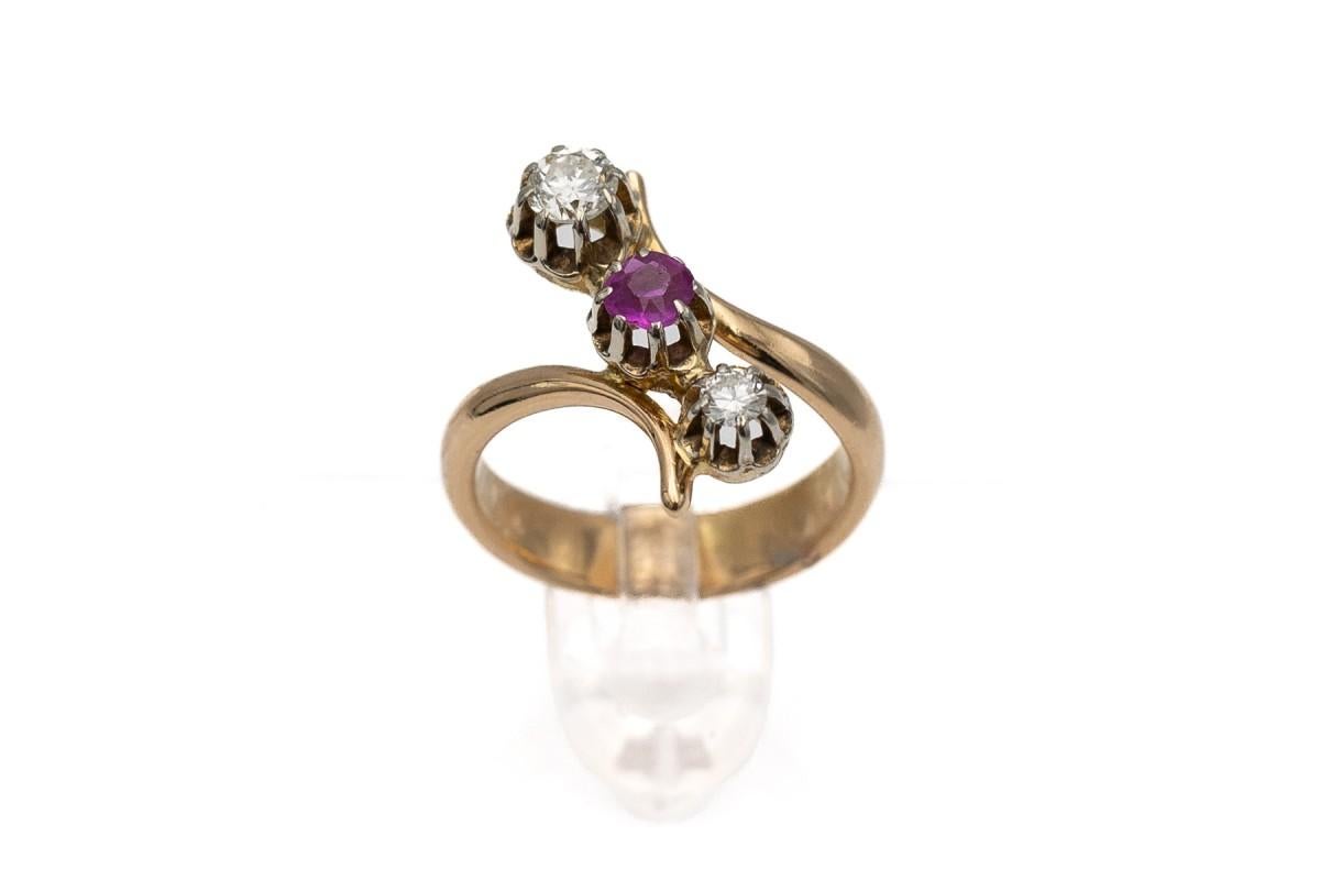An old French ring with a timeless shape, the so-called trilogy

A centrally placed beautiful pink-red ruby weighing 0.25ct surrounded by two bright brilliant-cut diamonds (color/purity H-I/VS2) with a total weight of 0.34ct

Ring made of 0.750