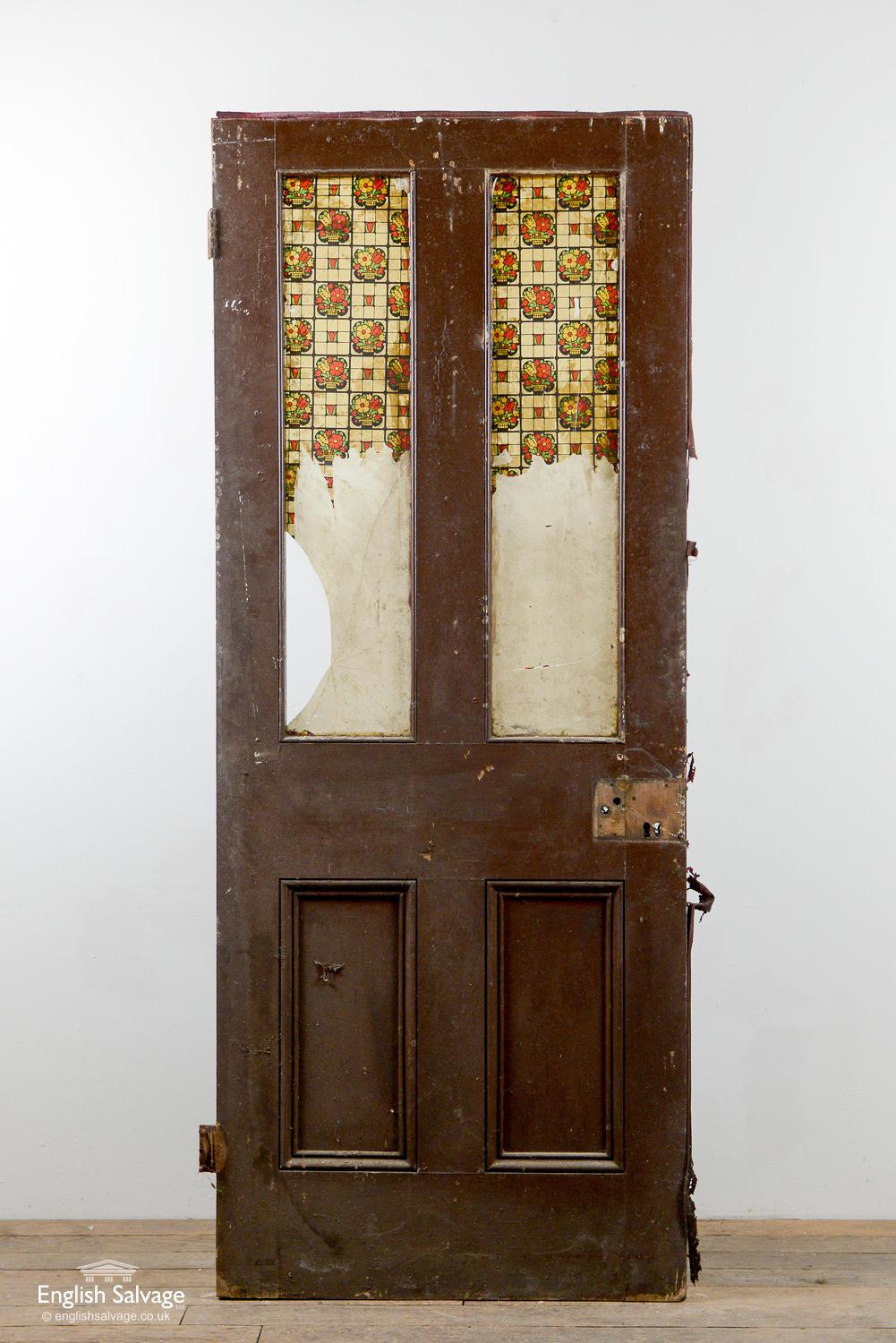 Salvaged Victorian door with four panels, the top two have been removed for glass. Remnants of an old intumescent strip around the edge of the door, two hinges and old handle, lock and nail holes present.