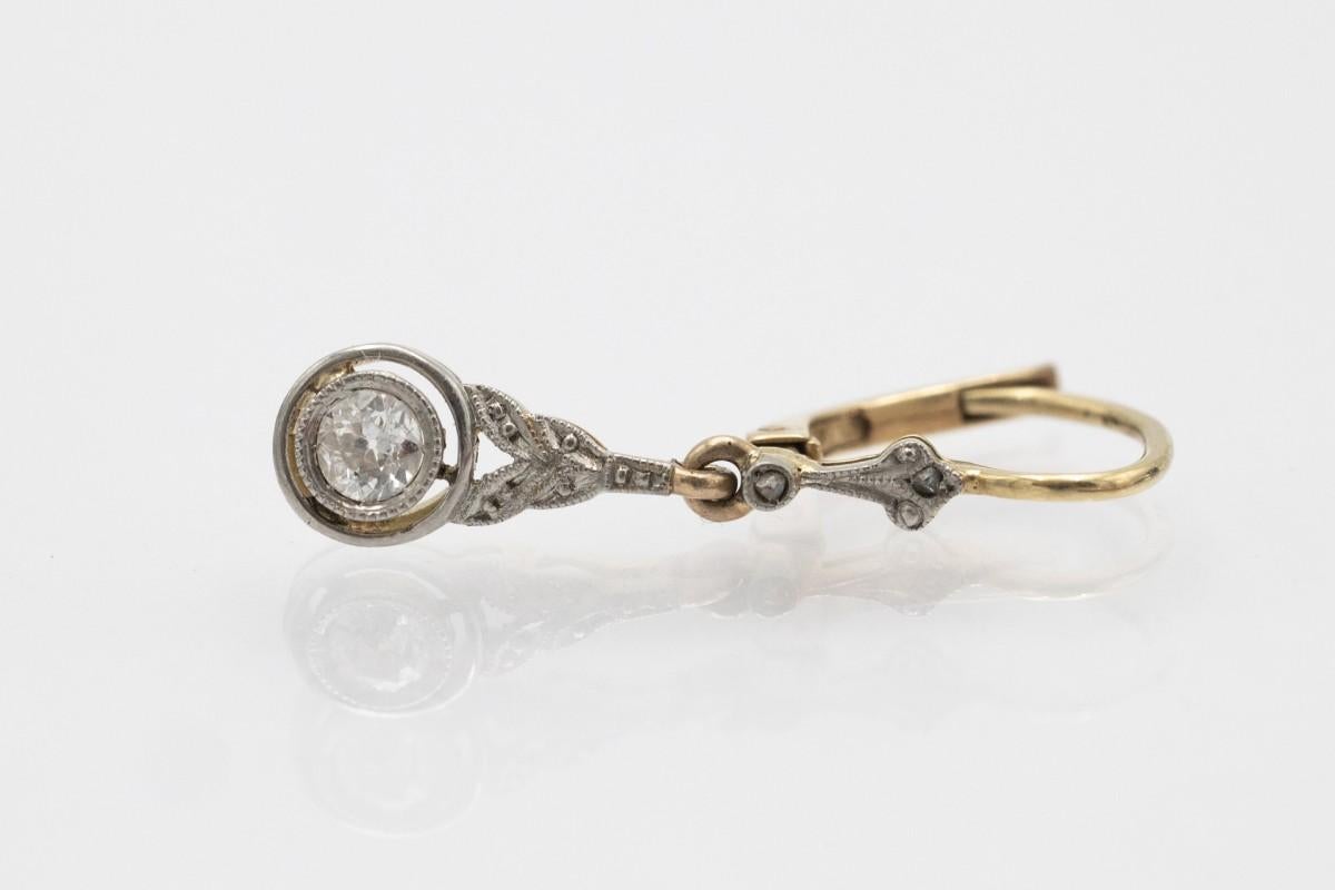 Orecchini pendenti in oro giallo 14 carati (finezza 585) ed elementi in platino. Orecchini unici decorati con vecchi diamanti taglio brillante con un peso totale di circa 0,40 carati.

Origine: Europa occidentale, anni '1930.

Lunghezza: 2.3