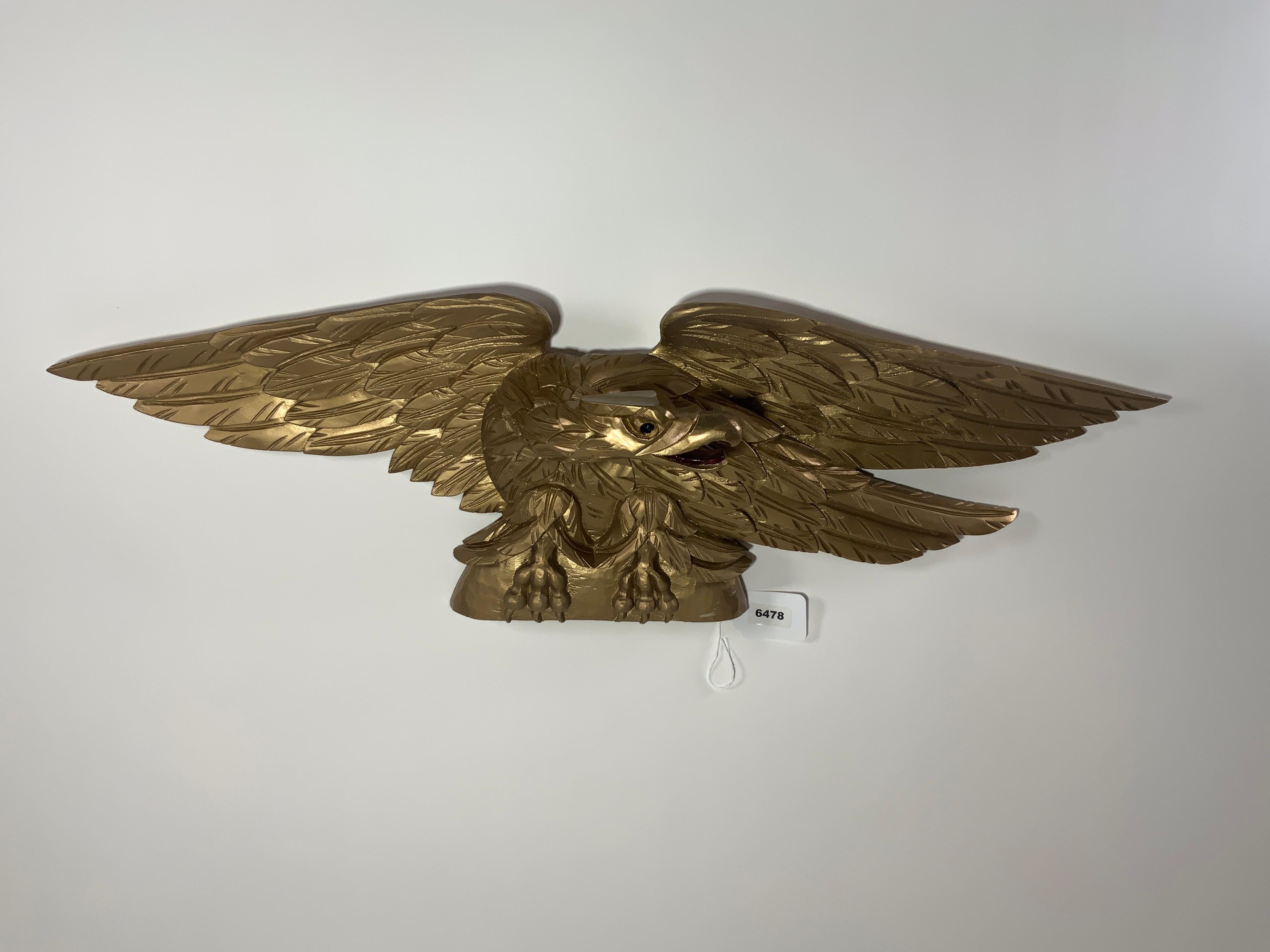 Carved eagle with pediment base. Heavily carved wings. Expertly executed. Flat bottom. Can be displayed on a mantle, over a door, or hung. Old gold painted finish.

Overall Dimensions: 11