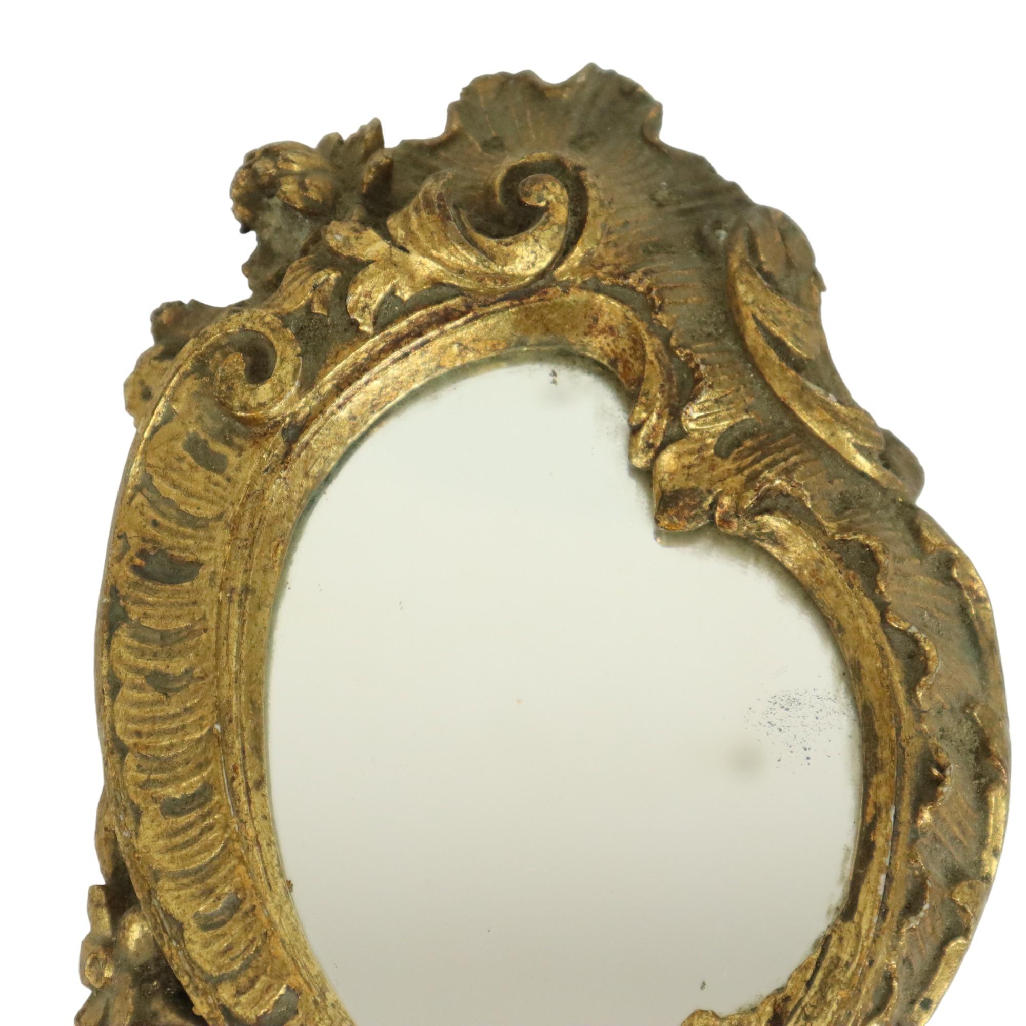 Old golden hand mirror, make-up mirror in classic baroque style, made of resin, circa mid-20th century.

This beautiful hand mirror is richly decorated with patterns, acanthus and a ribbon, the back wall has been replaced, a hanger has been added so
