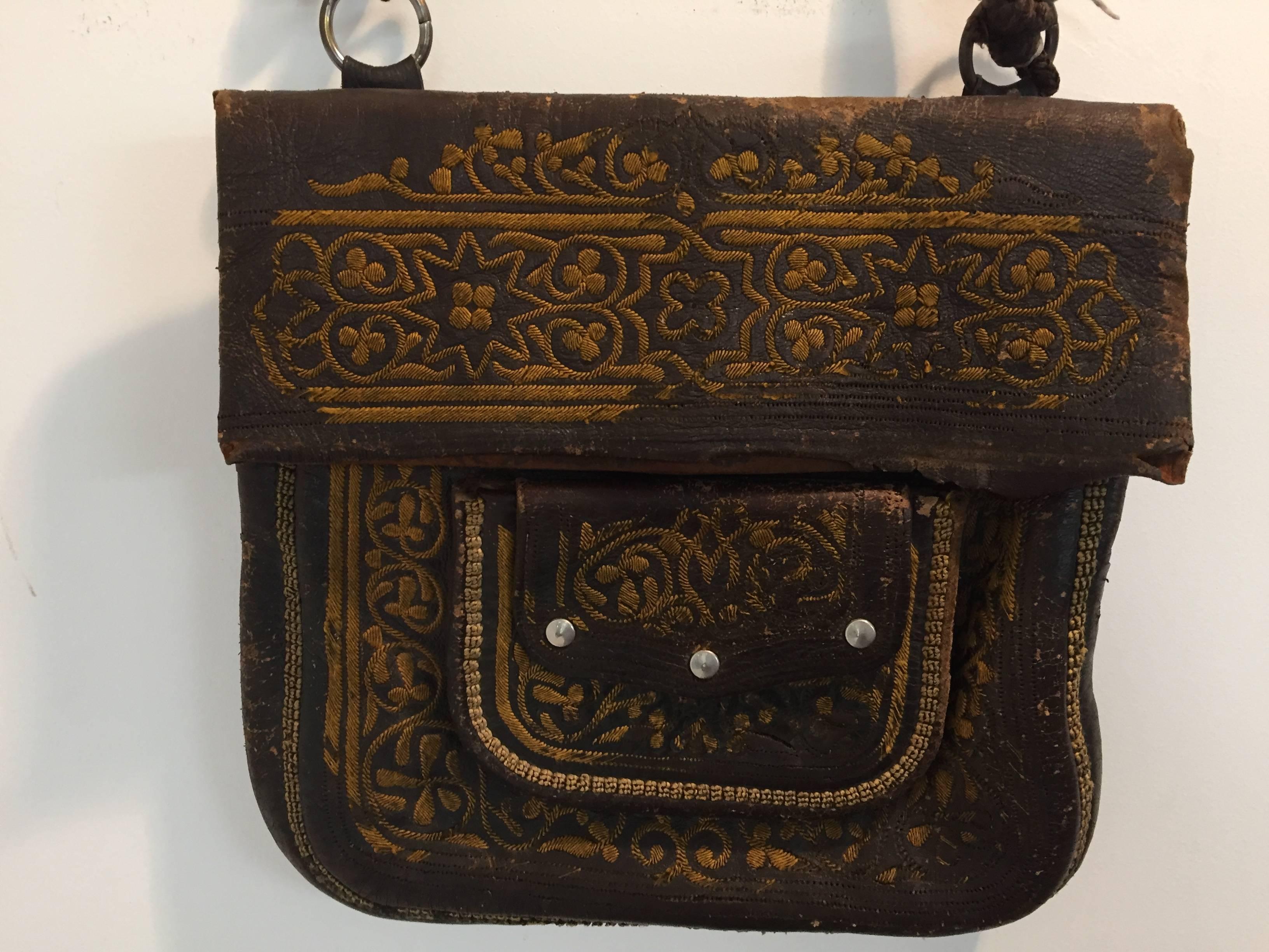 Old leather African Moroccan satchel bag with flap decorated with tribal embroideries.
Hand-tooled in Marrakech, this is an old antique man shoulder slim bag, merchants in Morocco when travelling used this bag under their coat to put their money and