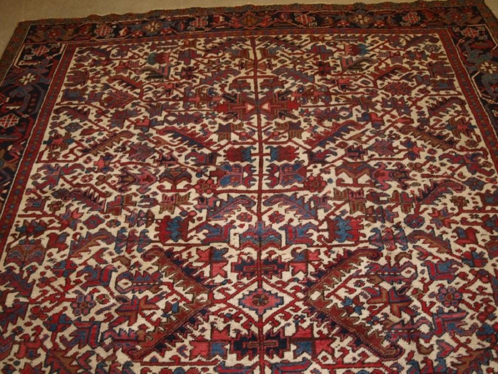 Alter Heriz-Teppich mit traditionellem Allover-Muster, sanfte Rot- und Blautöne auf elfenbeinfarbenem Grund, die einen leichten Eindruck vermitteln Klassische dunkle indigoblaue Bordüre
CIRCA 1920

Der Teppich ist in ausgezeichnetem Zustand mit