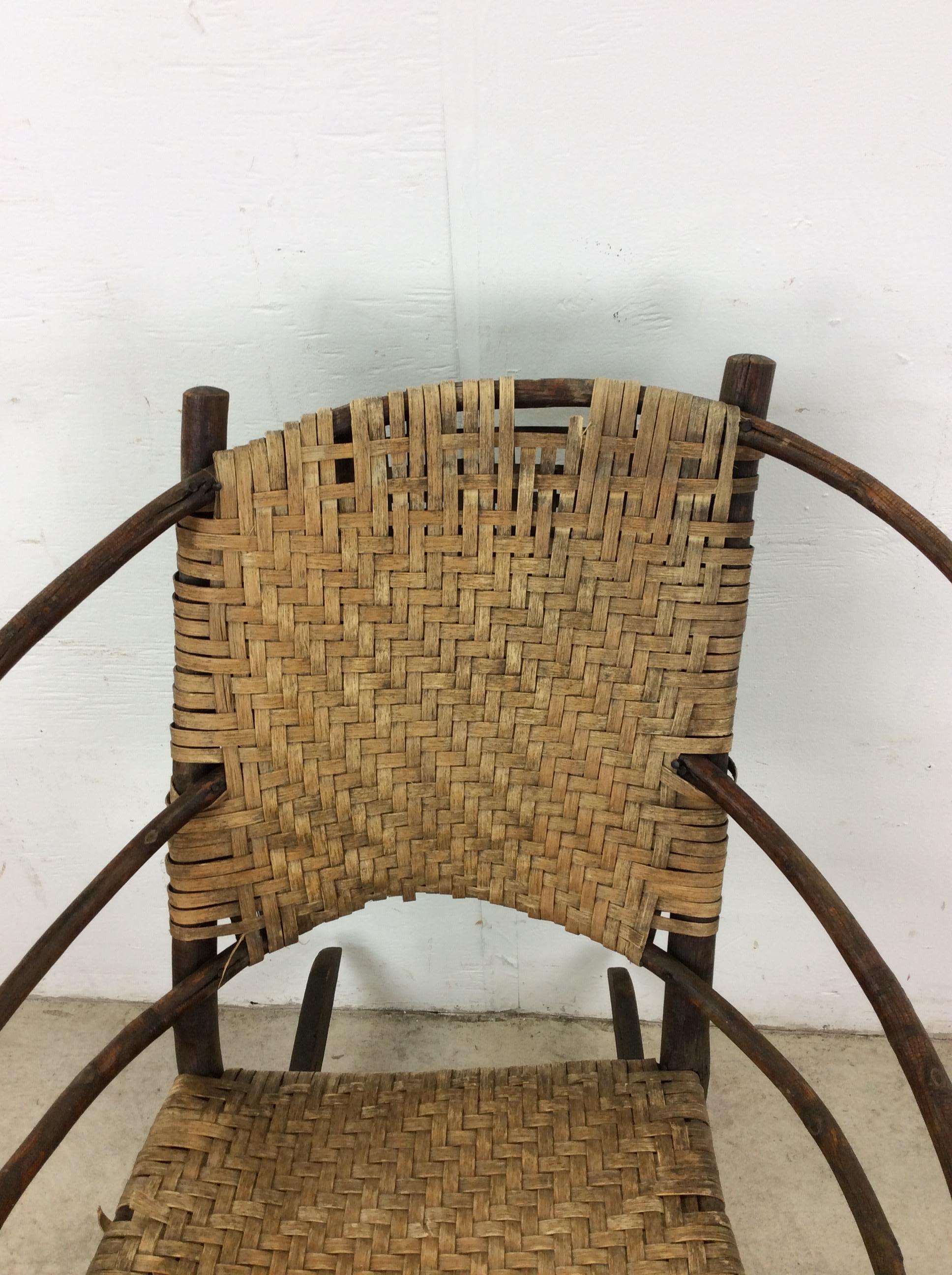 Esta silla de estilo Adirondack antiguo presenta una construcción rústica de madera de nogal curvada, asiento de caña y base mecedora.

Dimensiones: 27w 31d 33h 17sh 27ah

Notas sobre el estado: La silla en sí está en buen estado. Ambiente muy