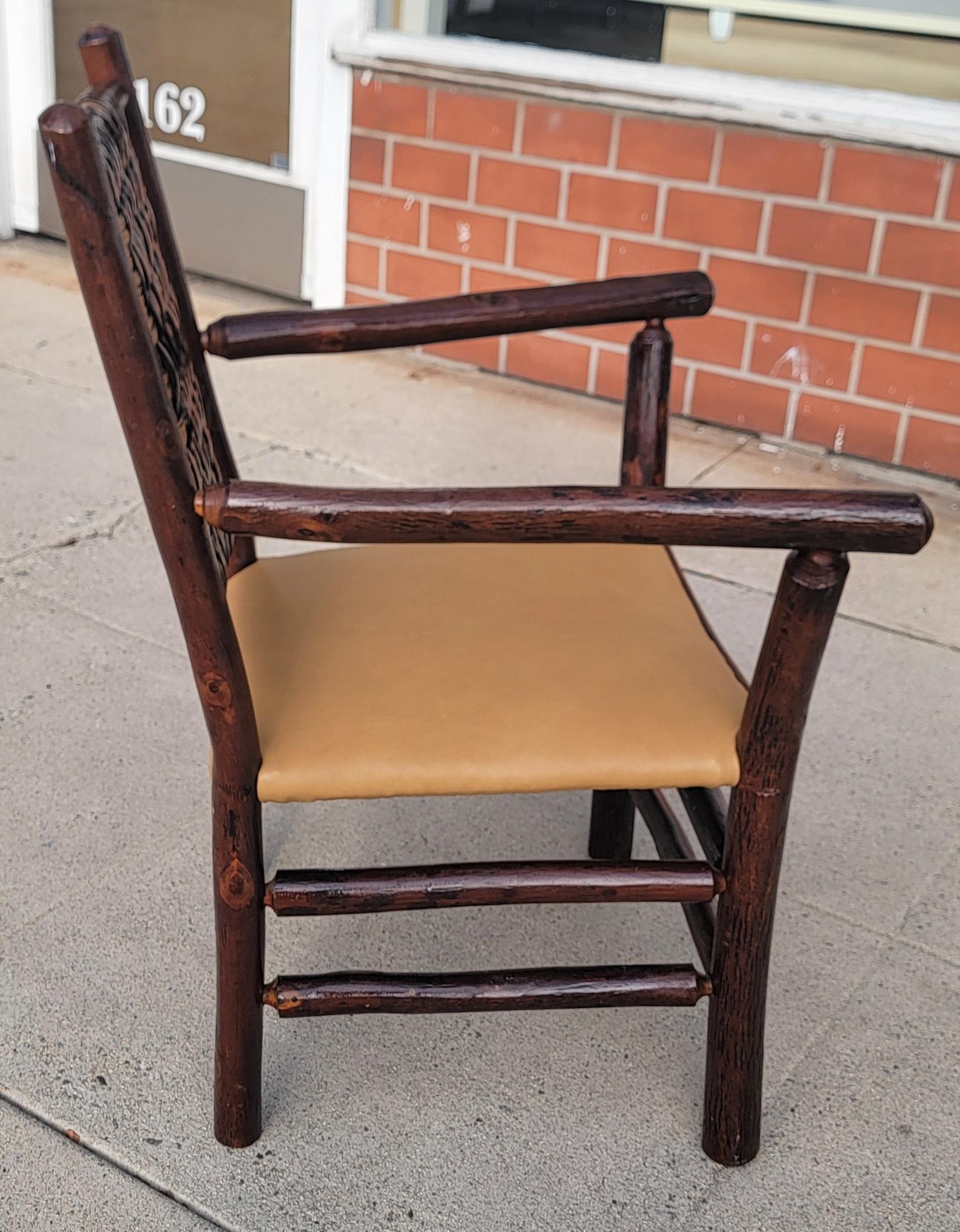 Sedia a bracci firmata Old Hickory con seduta in pelle appena sostituita. Il supporto è intrecciato a mano e la sedia è in ottime condizioni.