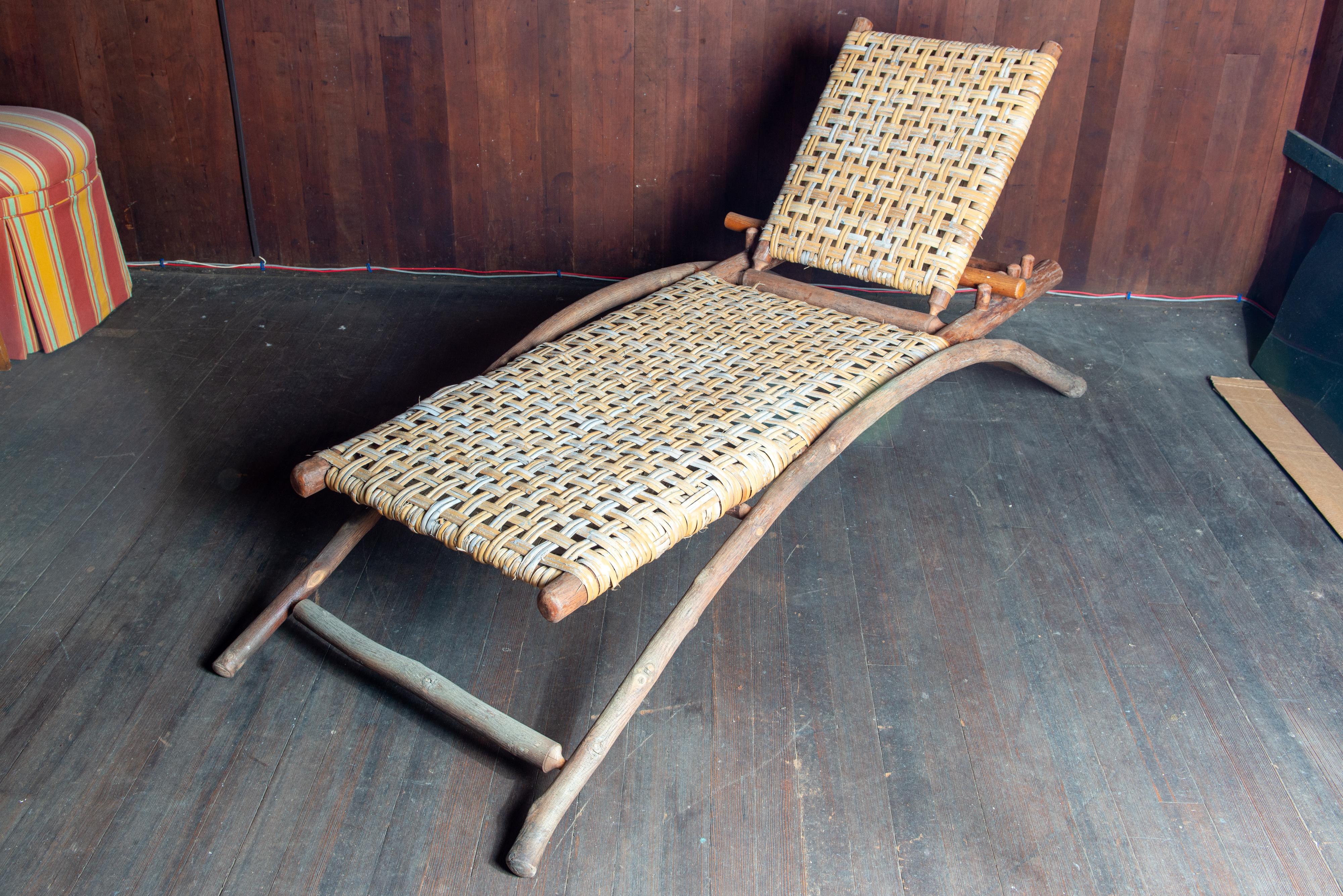 This hickory chaise lounge is labeled: Old Hickory Shelbyville, IN. Est 1899.
It dates from the 1990s. The chaise lounge's structureis createdwith slender hickory tree trunks. The inner bark strips (caning) were woven to create soft yet durable