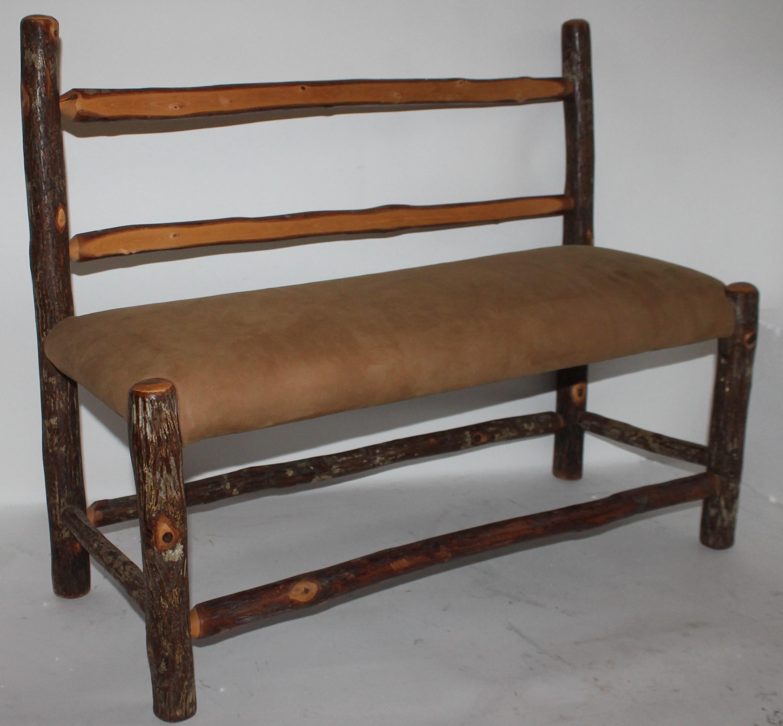 This fun handmade Old Hickory child's bench with a suede seat. It has been newly upholstered in leather.