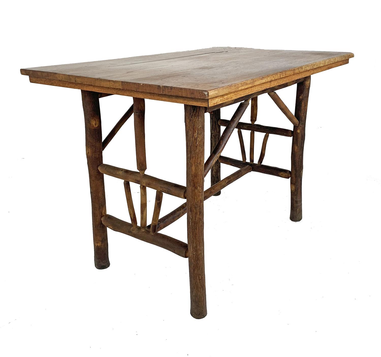 The hickory base of this handsome table has lower side panels with hickory pole fans, one low and one high cross stretcher, and four diagonal top braces. The three-board oak top has integral expansion grooves. It appears as “No. 219 Table” in the