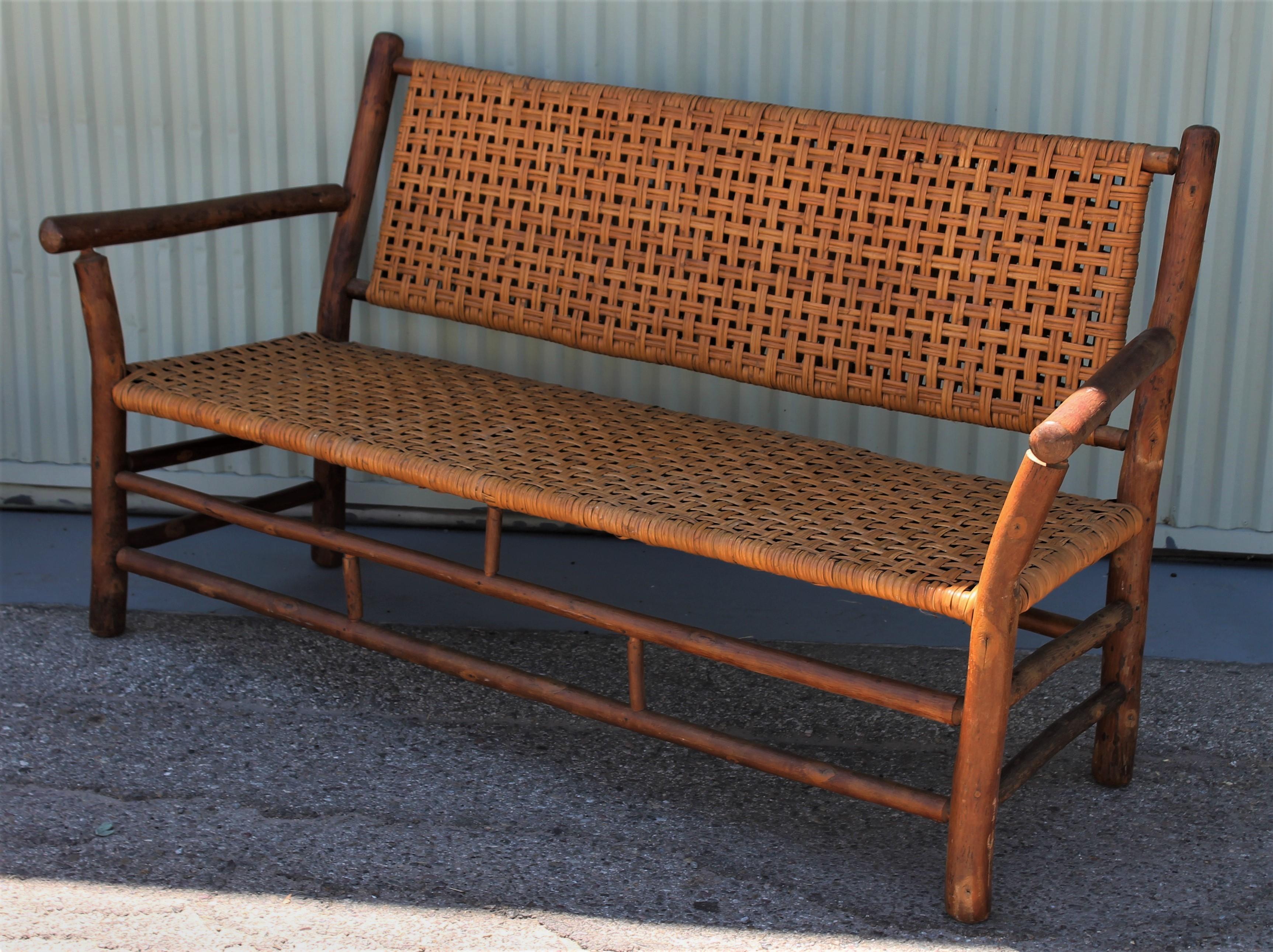 This settee measures: 66 x 24 x 37 x sh 16.5 and is in pristine condition. It has the original woven cane seat and back. It had a paper label at one time from Old Hickory Furniture Company in Martinsville, Indiana. The condition is pristine.